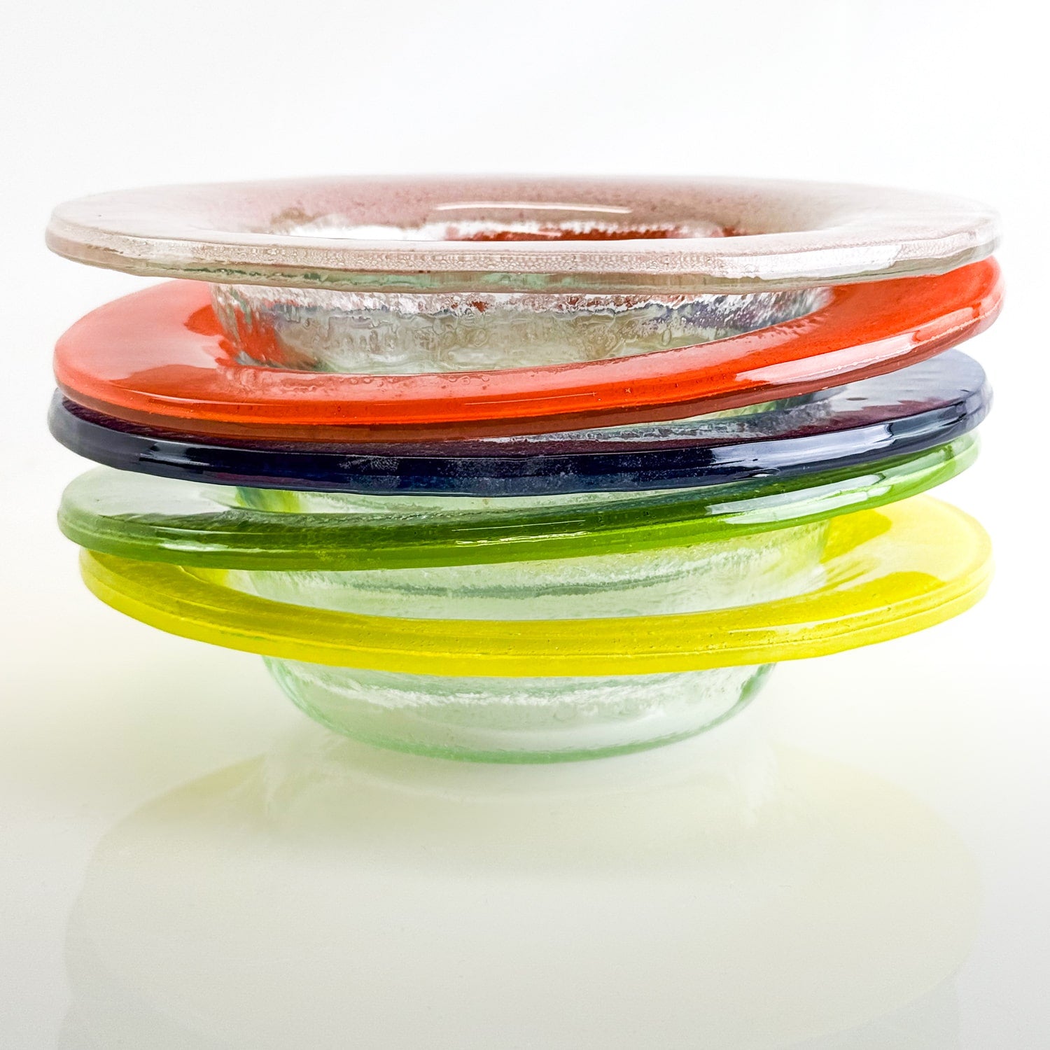 Stack of glass bowls in colorful shades on a white background