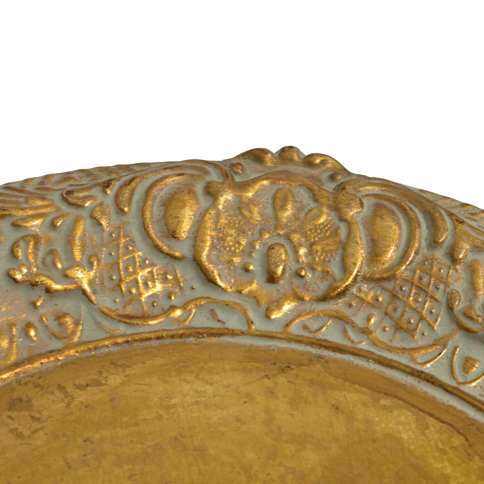 Decorative Florentine carved wood charger tray with gold distressed finish, showcasing intricate design on a wooden surface.
