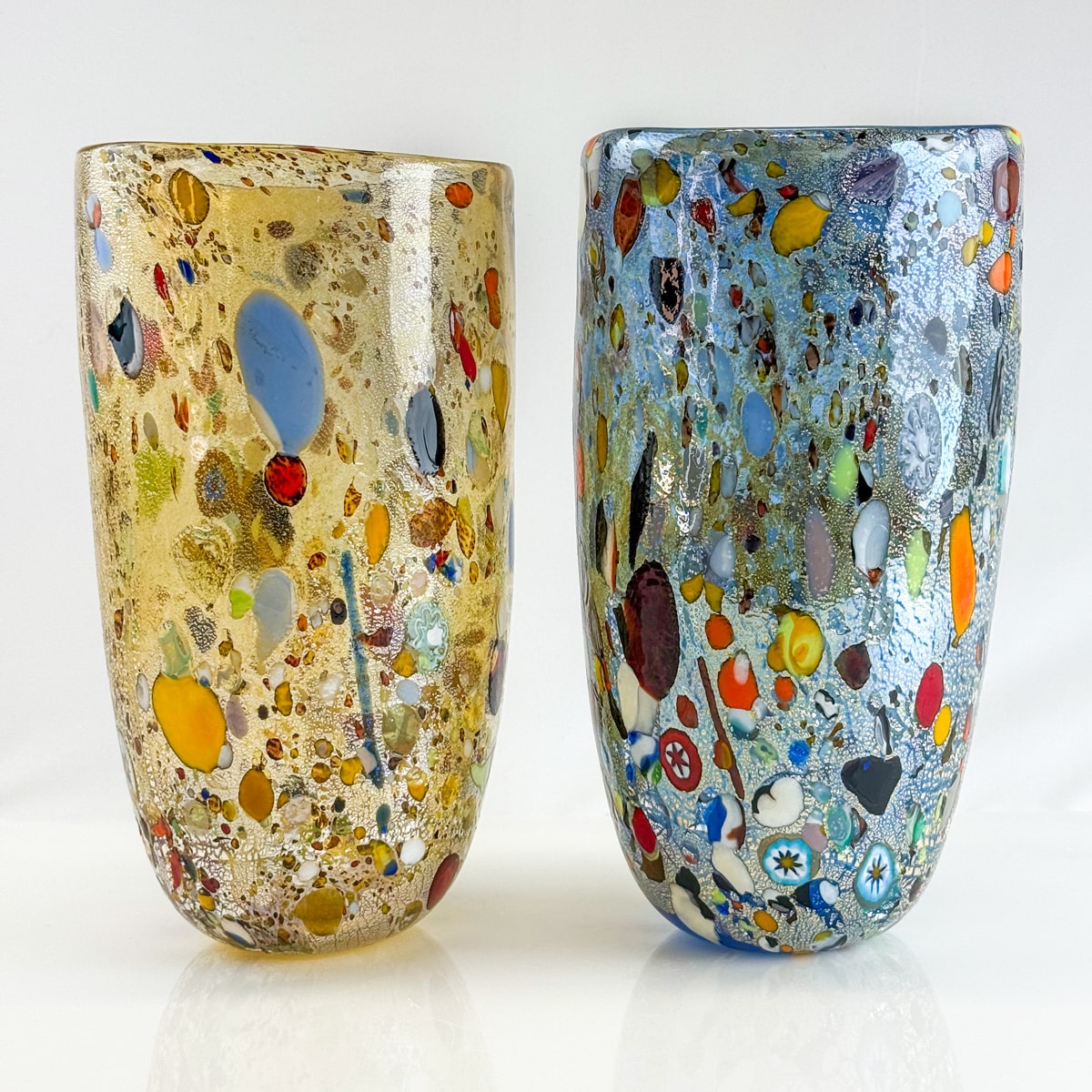 Two colorful glass vases with a mosaic pattern on a white background