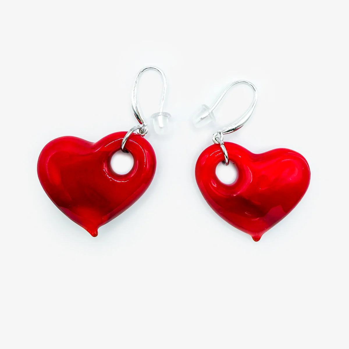 A jewelry set featuring three glossy red heart-shaped glass pendants and earrings on a black cord necklace with silver-tone hardware, displayed on a clean white background.