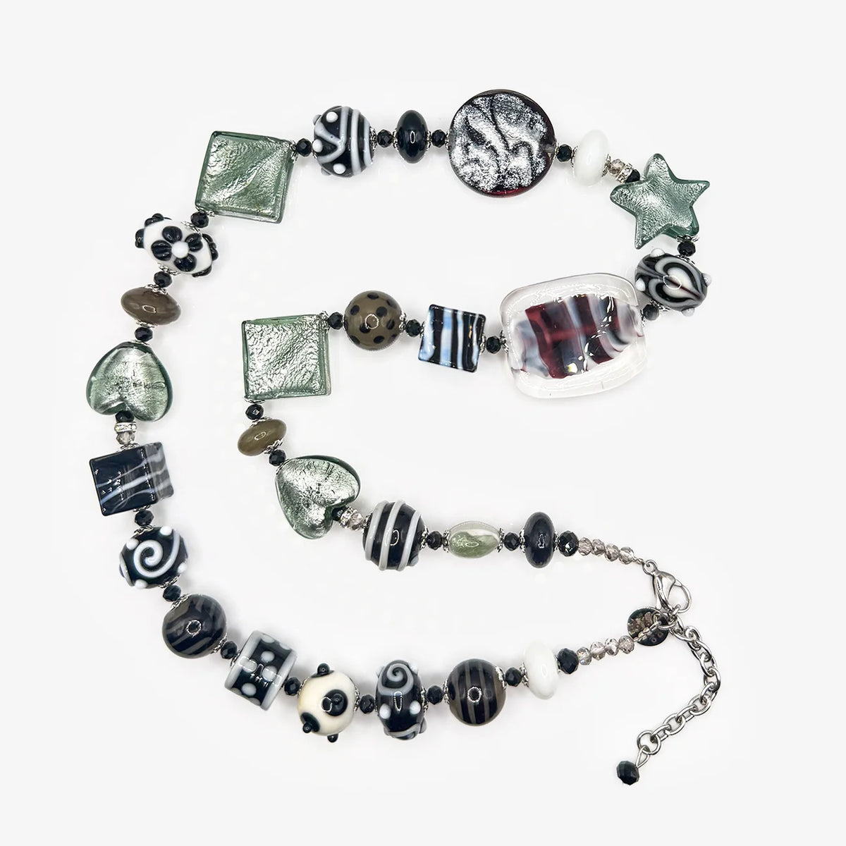 A handmade glass bead necklace featuring a variety of patterns including stripes, swirls, textured squares, and a clear glass cube, displayed on a light gray background.