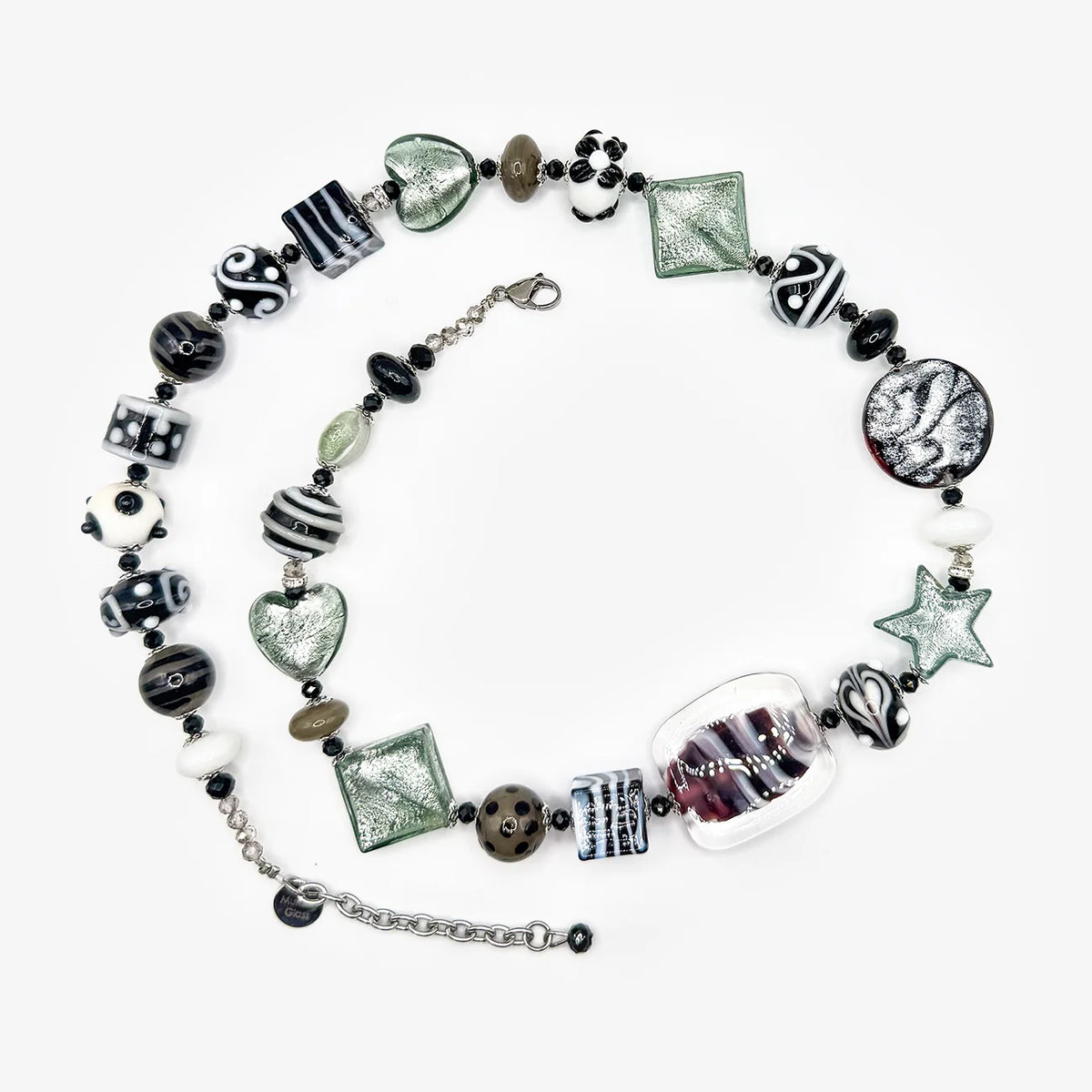 A handmade beaded necklace with a variety of glass charms, including striped beads, a heart-shaped glass piece, a star, and a clear glass cylinder, displayed on a light gray background.
