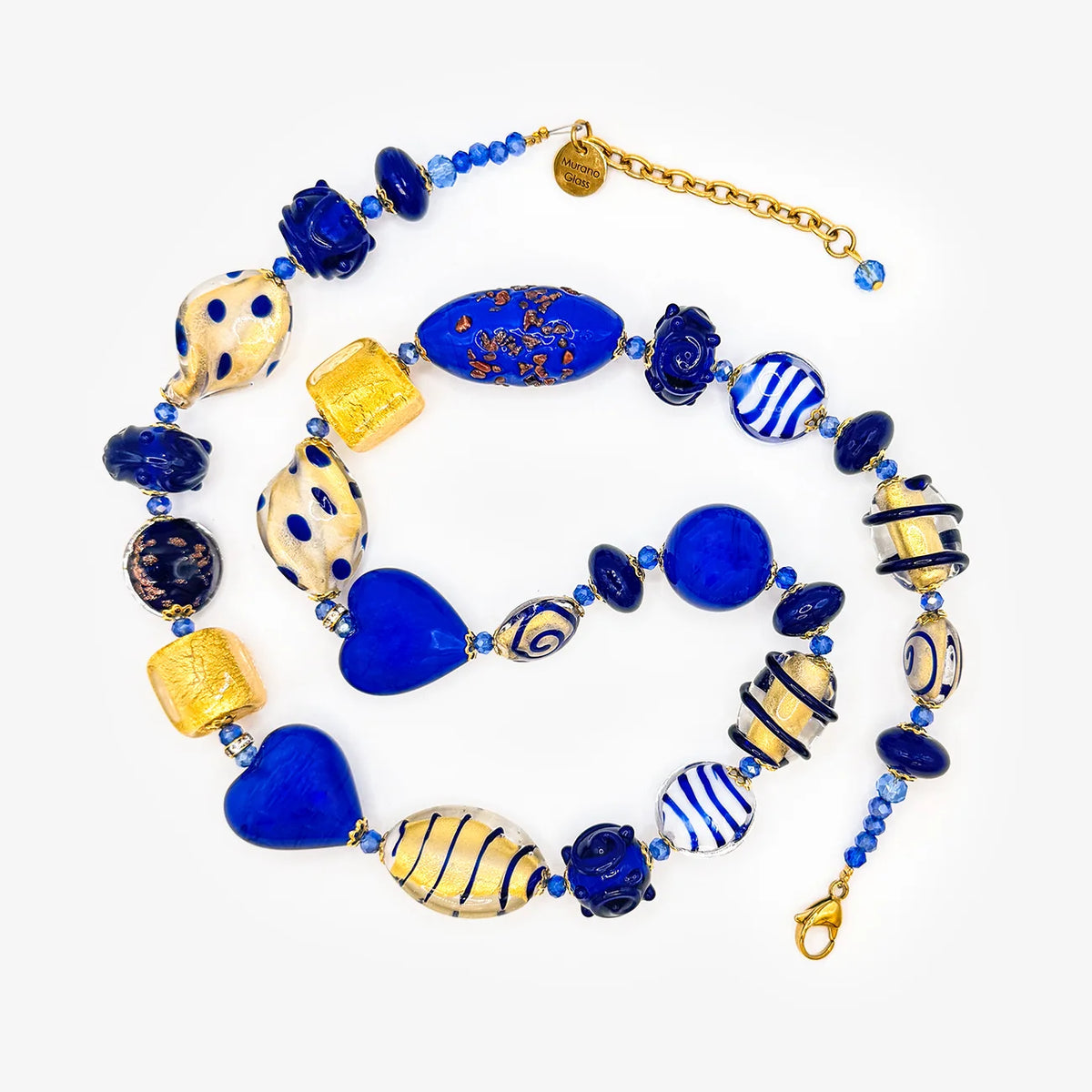 A multi-piece glass bead jewelry set featuring blue, gold, and cream lampwork beads, including a heart-shaped bead, striped beads, and a gold chain extender, displayed on a clean white background.