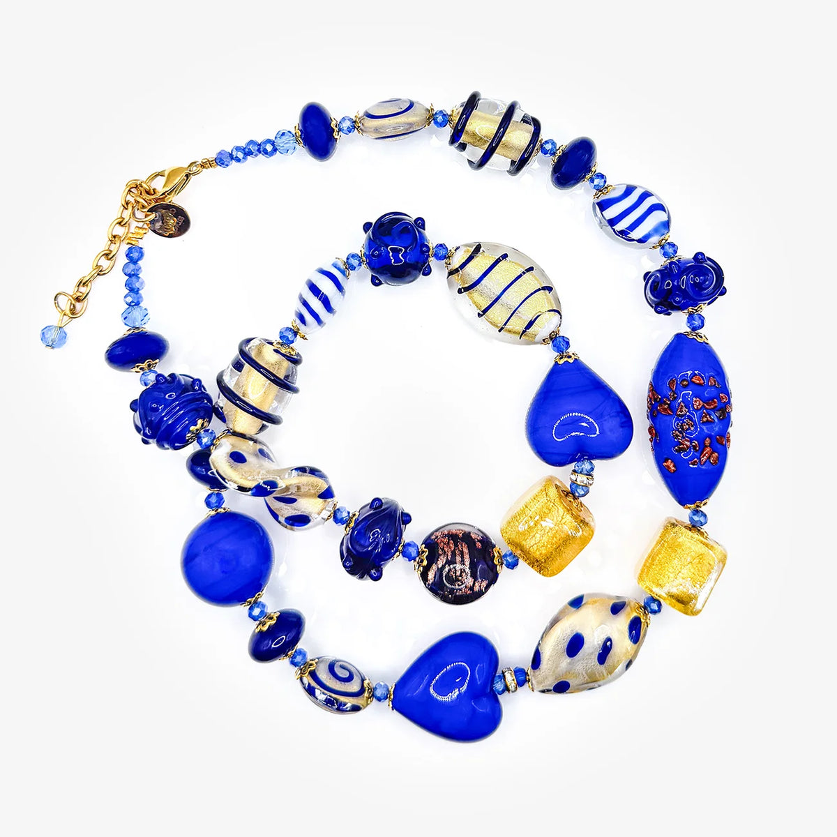 A multi-piece glass bead necklace and bracelet set featuring vibrant cobalt blue, white, and gold glass beads, with a gold clasp, photographed on a clean white background.