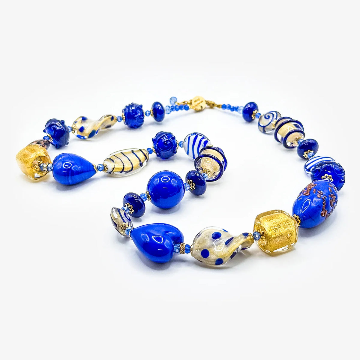 A handmade glass bead necklace featuring vibrant cobalt blue beads, gold-flecked glass beads, striped glass beads, and a small gold clasp, displayed on a clean white background.