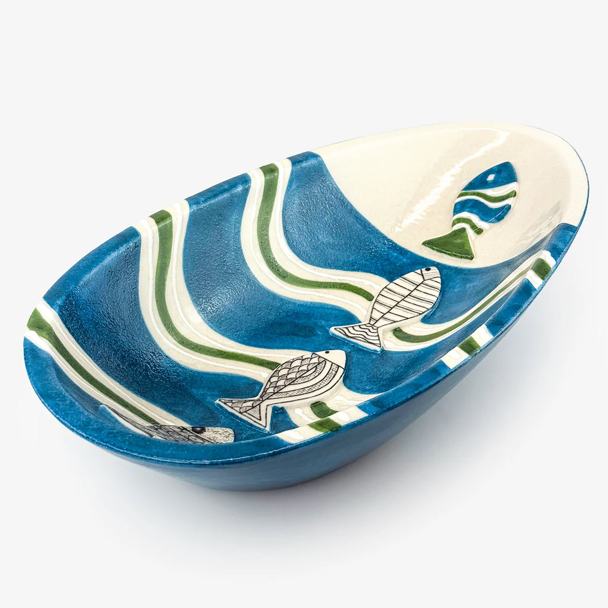 An oval ceramic serving bowl with a blue and white wavy pattern and fish illustrations, shown on a light gray background.