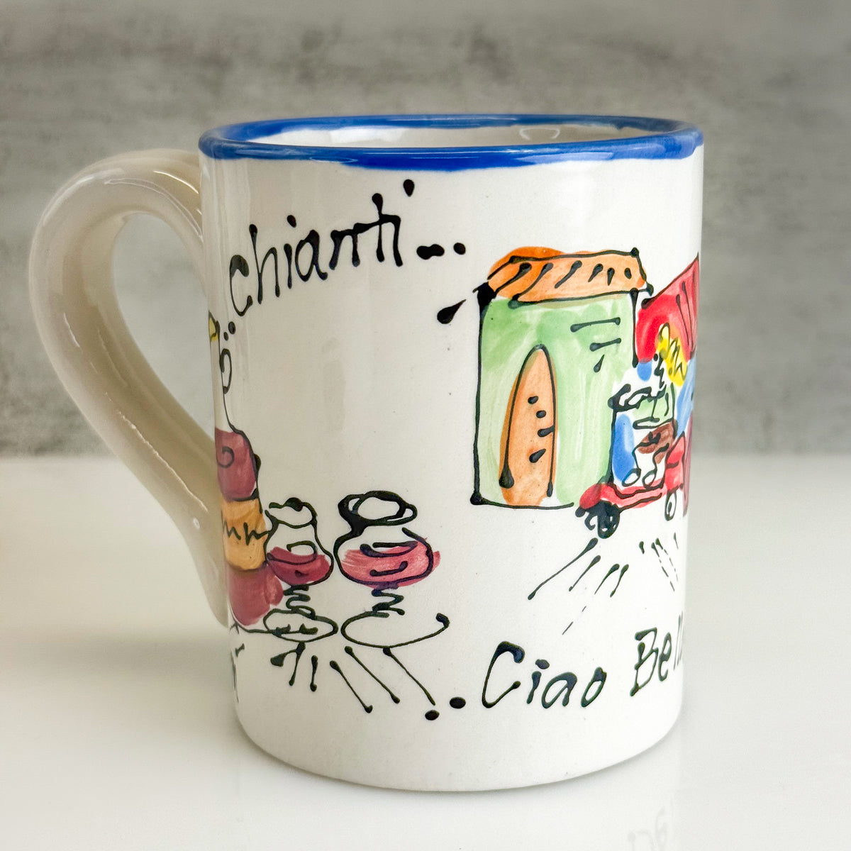 Ceramic mug with colorful illustrations and text on a neutral background