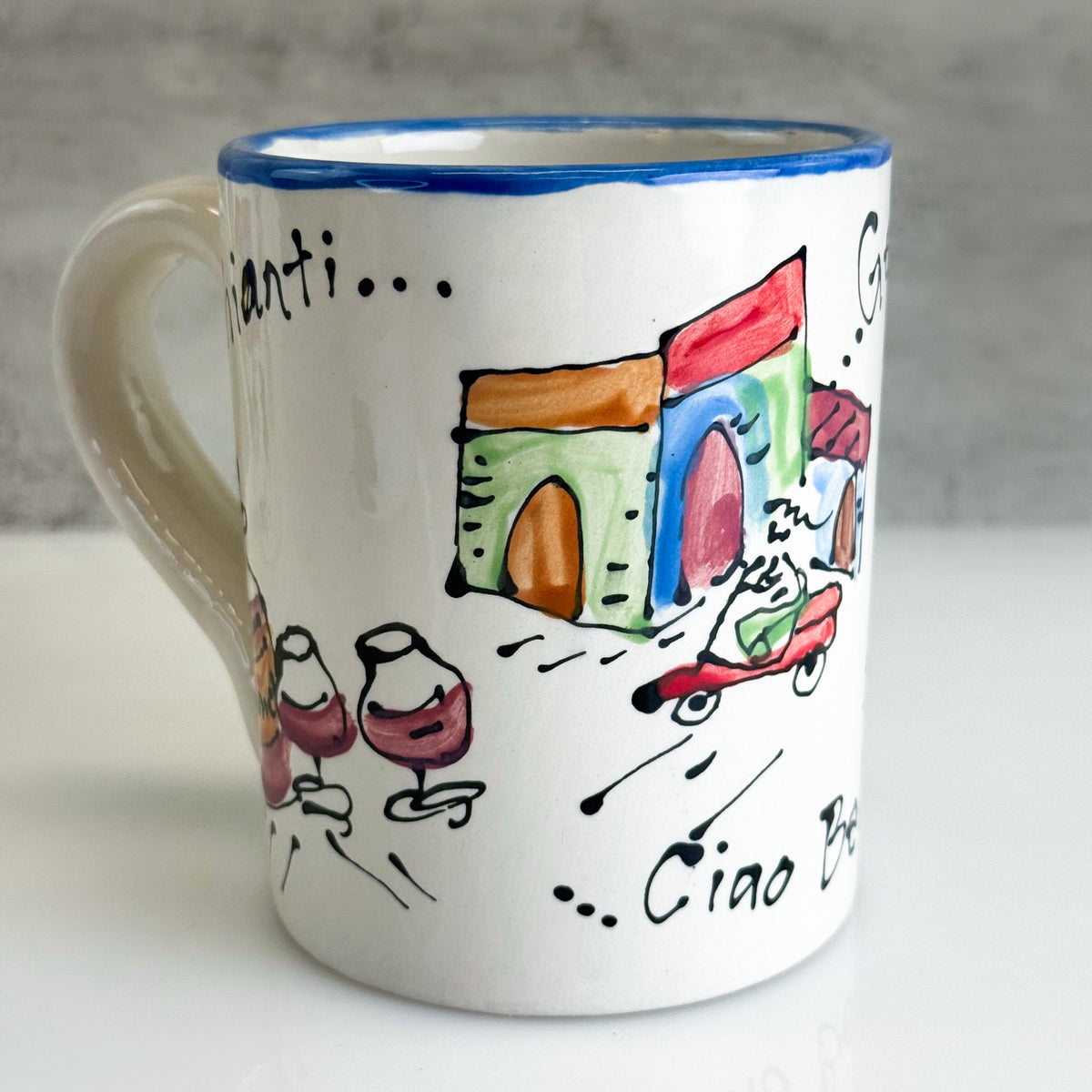 White mug with colorful illustrations and text on a gray background