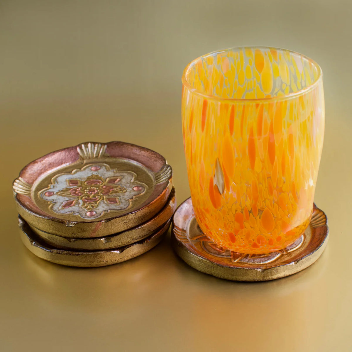 Set of Florentine wood coasters from My Italian Decor displayed on decorative trays, showcasing intricate Italian craftsmanship.