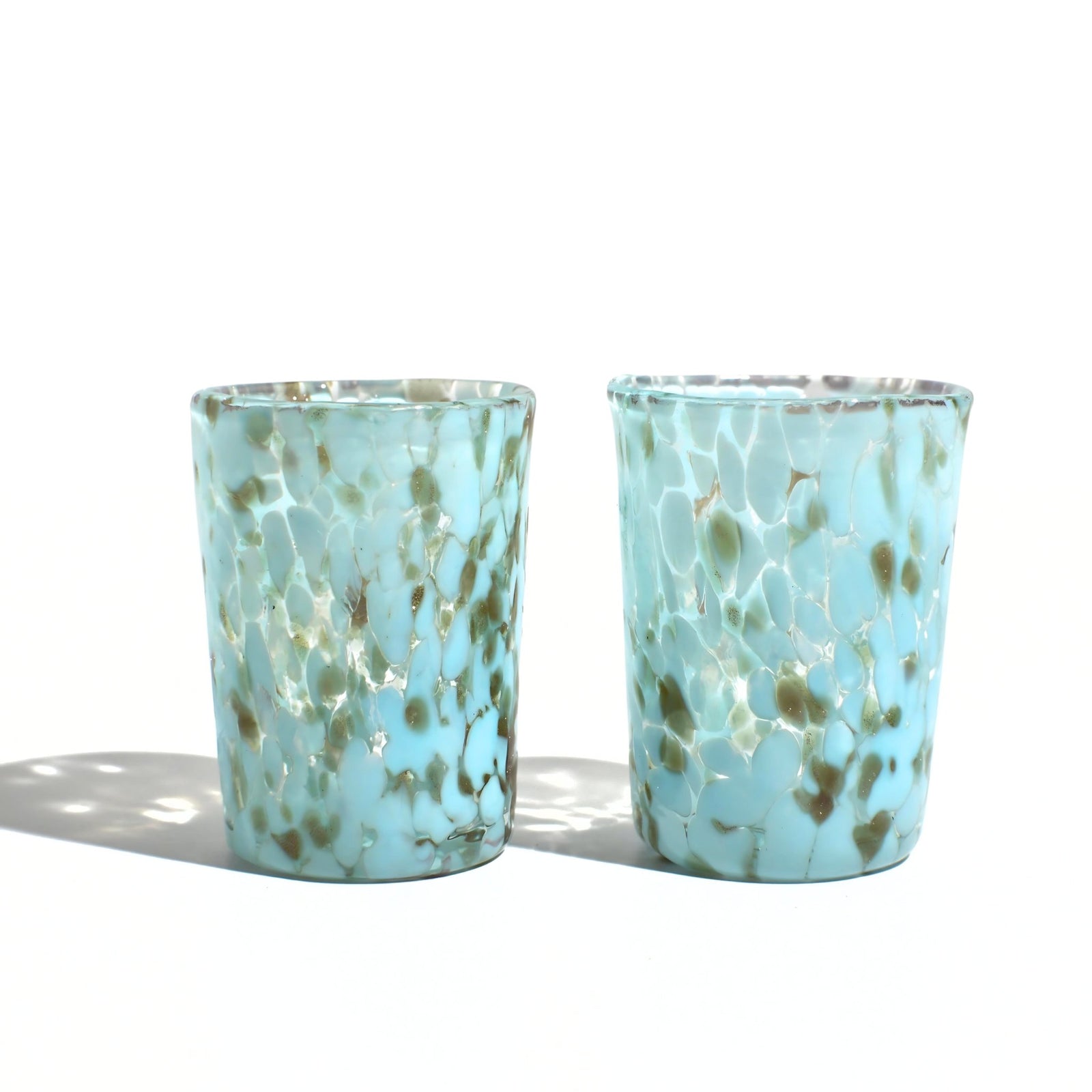 Stacked Murano Glass Tesoro shot glasses from Italy with colorful, intricate designs, showcasing artisanal craftsmanship and vibrant patterns.