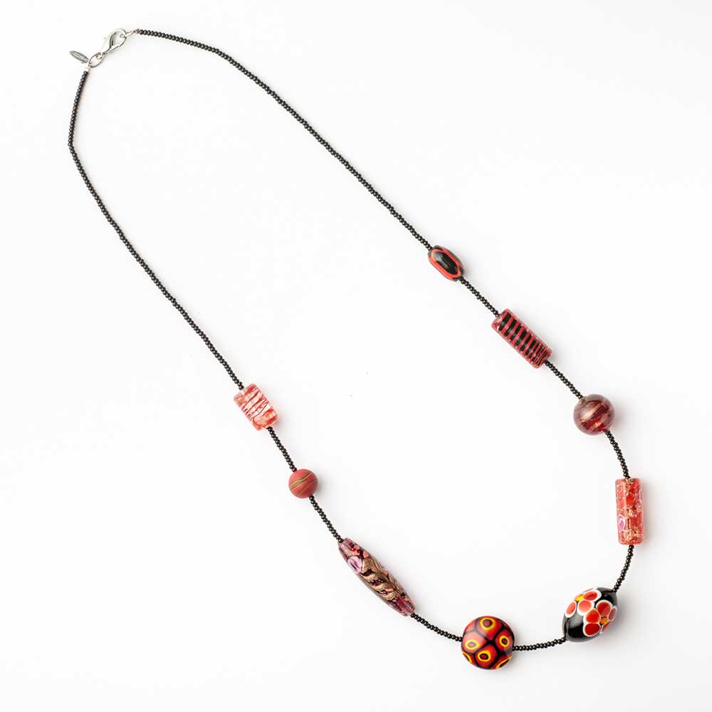 Red Murano glass bead necklace by 9th Heaven, featuring colorful handcrafted glass beads, styled on a simple chain.