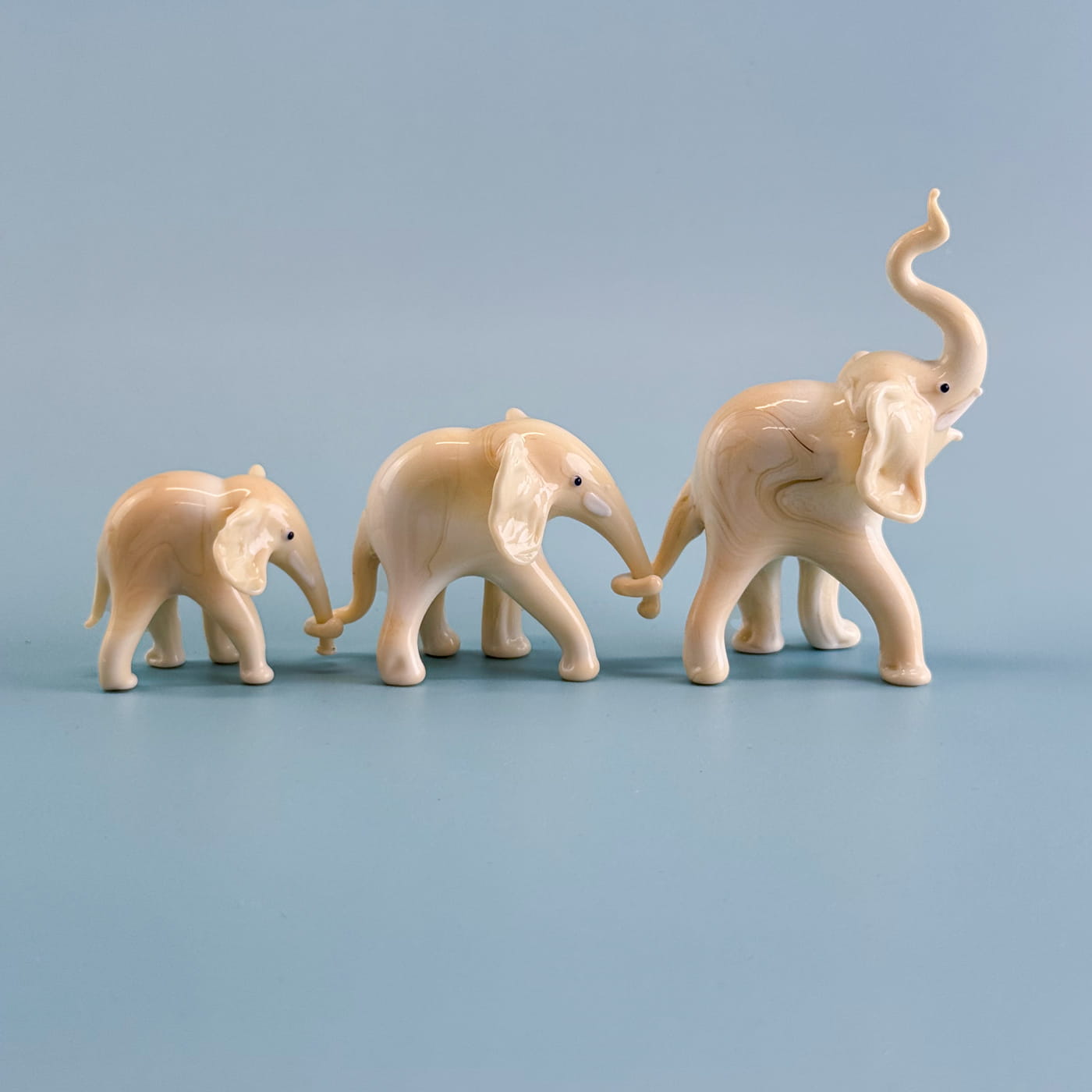 Set of three handcrafted Murano glass elephant figurines from Italy, showcasing colorful and detailed craftsmanship.