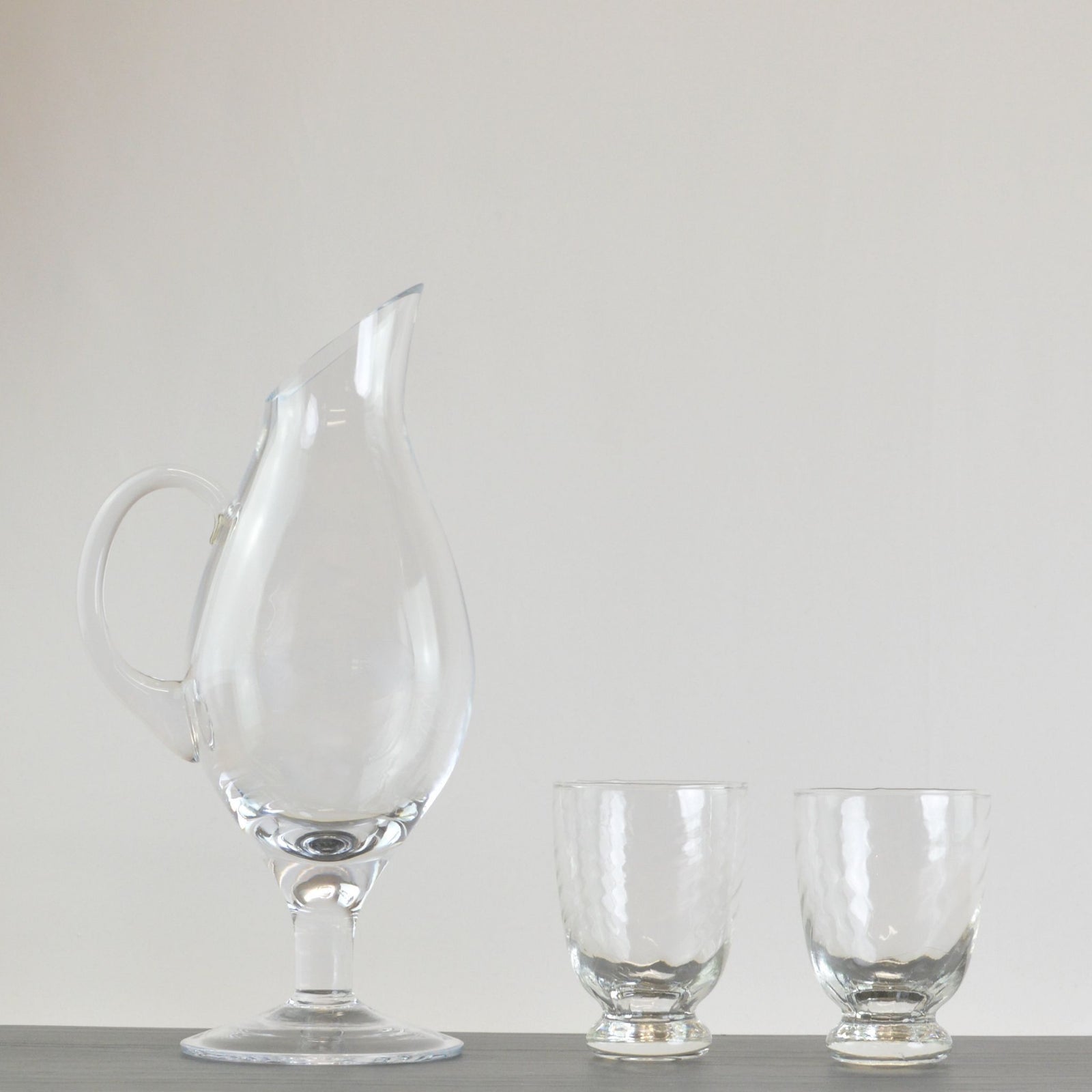 Clear glass Fiume decanter with footed base, Italian-made, elegant design for wine or spirits display.