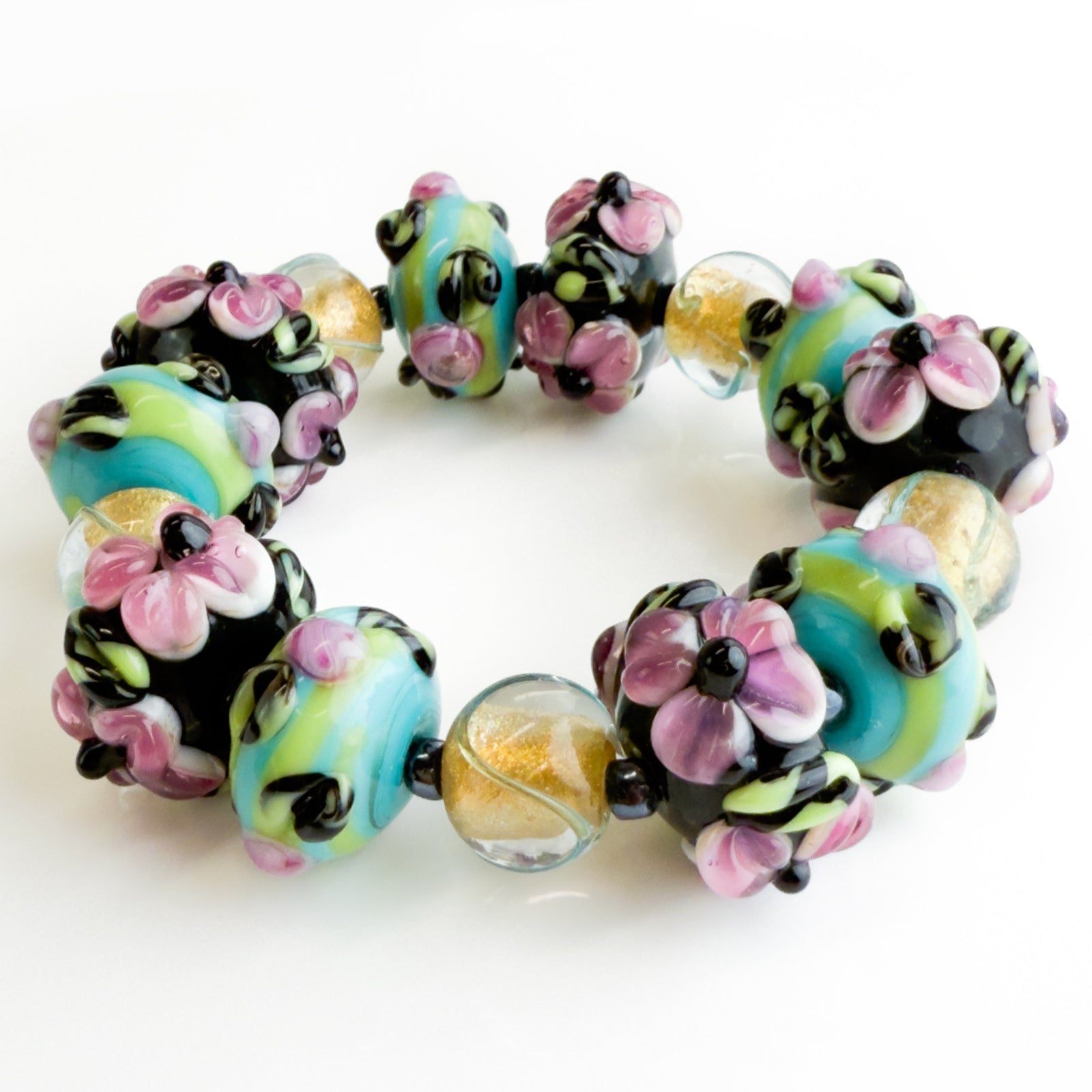 Handcrafted floral black and pink beaded bracelet and earrings set by Crazy 4 Glass, featuring colorful floral and fruit designs.
