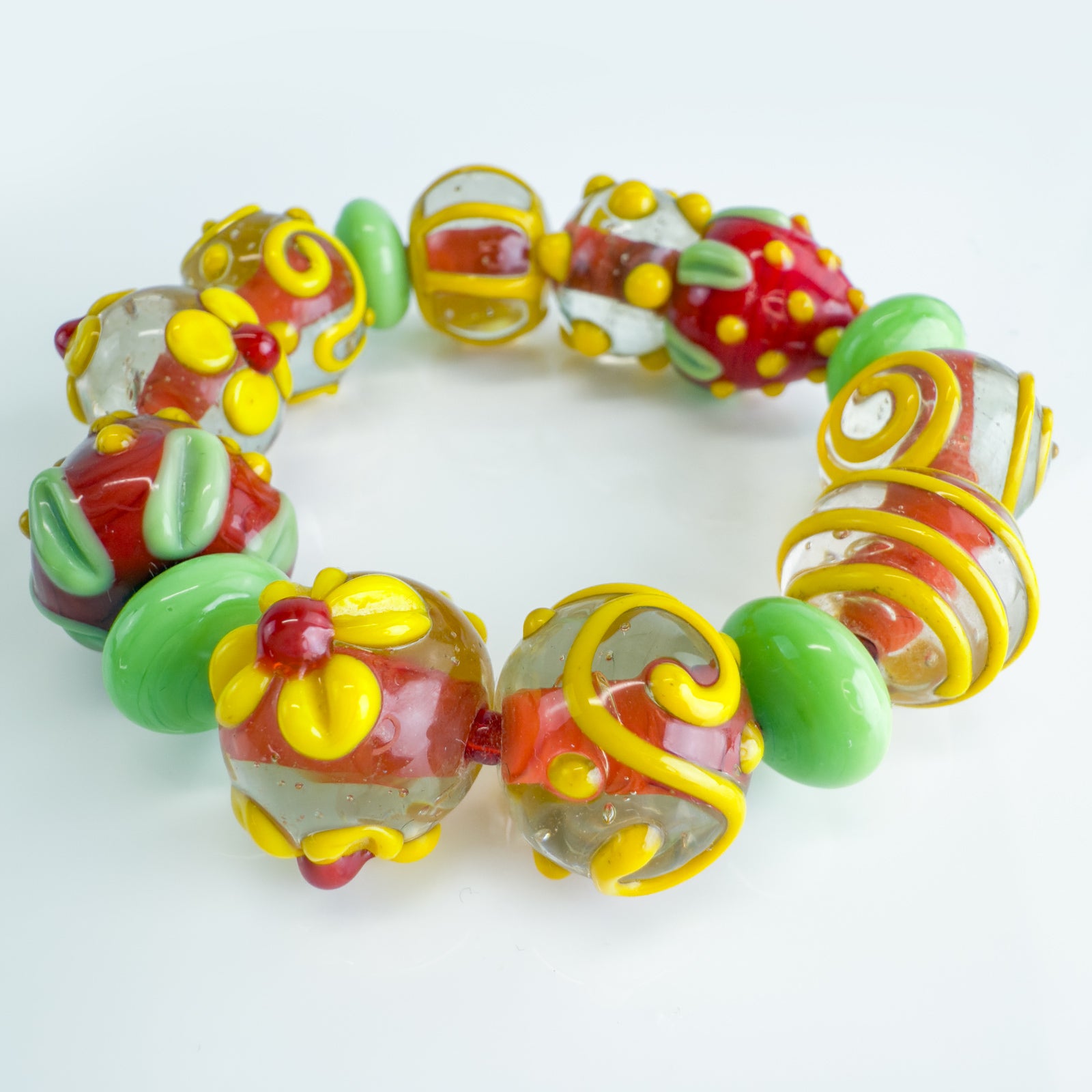 Colorful strawberry beaded fruit bracelet made with Murano glass, featuring floral and fruit charm details.
