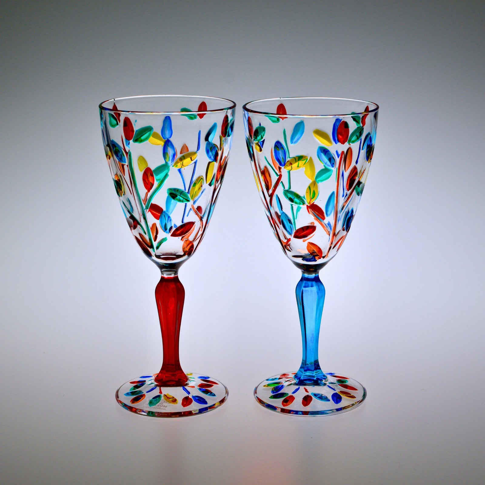 Pair of DZ Flowervine wine glasses in red and turquoise, elegant Italian-made wine glasses for enjoying beverages.