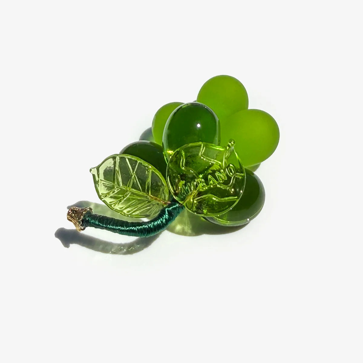 Mini Murano glass grape cluster in multiple colors, made in Italy, artificial floral decoration displayed in a bowl.