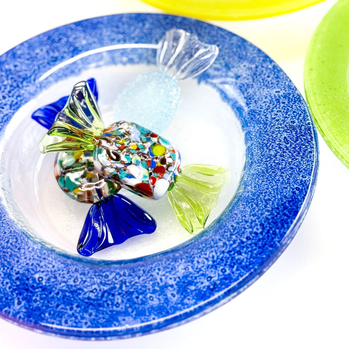 Glass candy in a glass bowl with a blue rim.