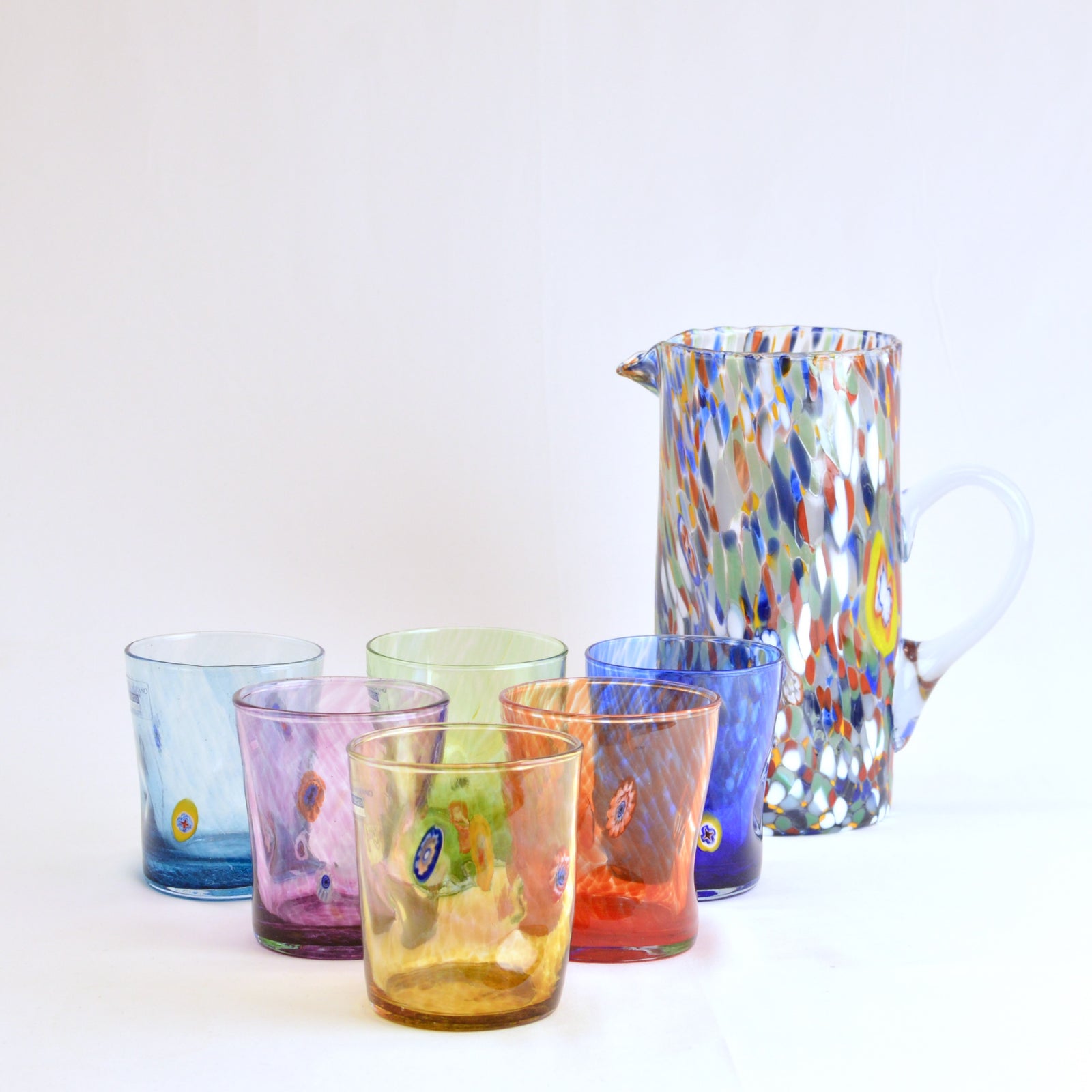 Six Liberty Italian glass tumblers by MZ arranged on a table, showcasing clear, elegant drinking glasses with a smooth finish.