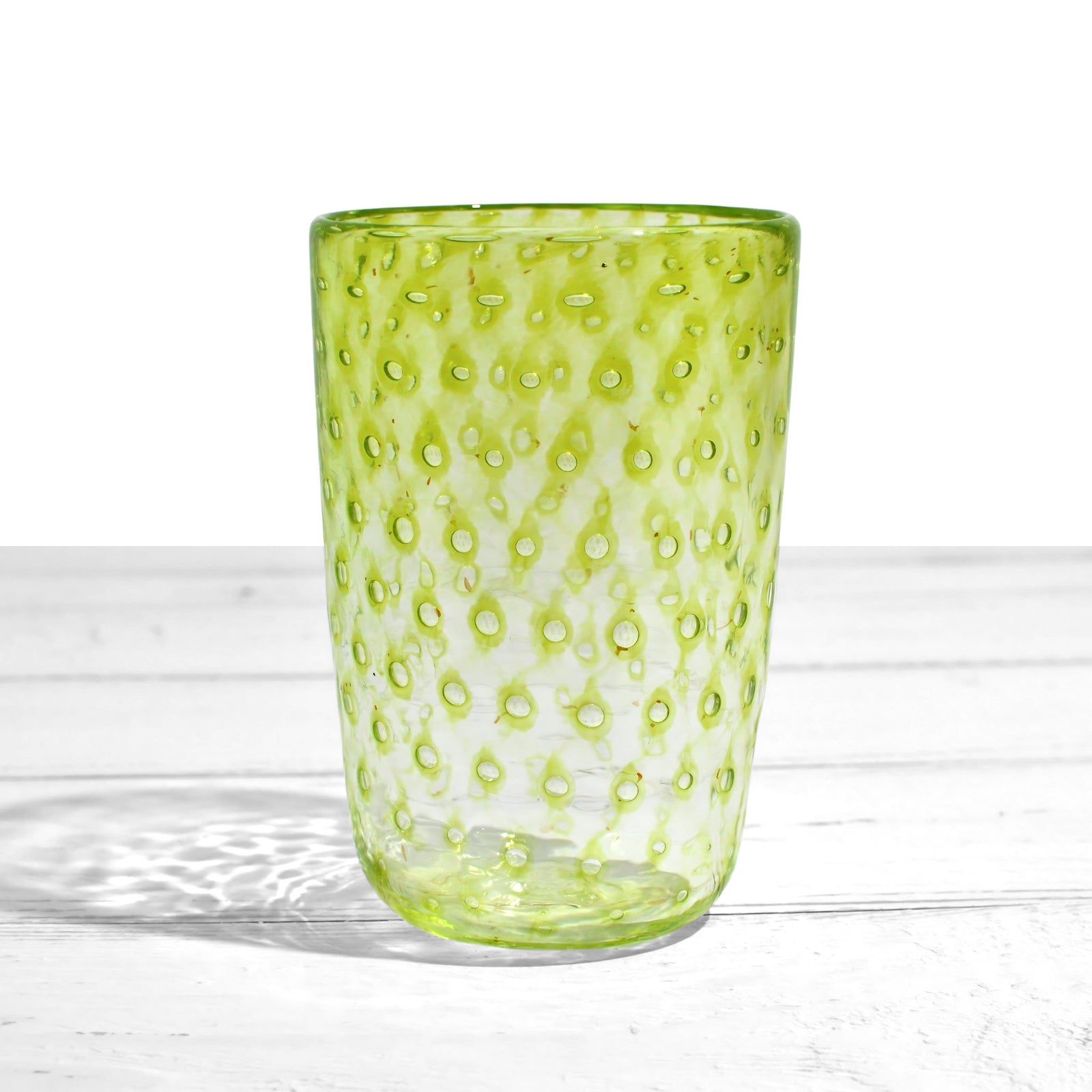 Colorful Ecco Murano tumbler glasses with orange, blue, violet, and lime hues, made in Italy, displayed on a neutral background.