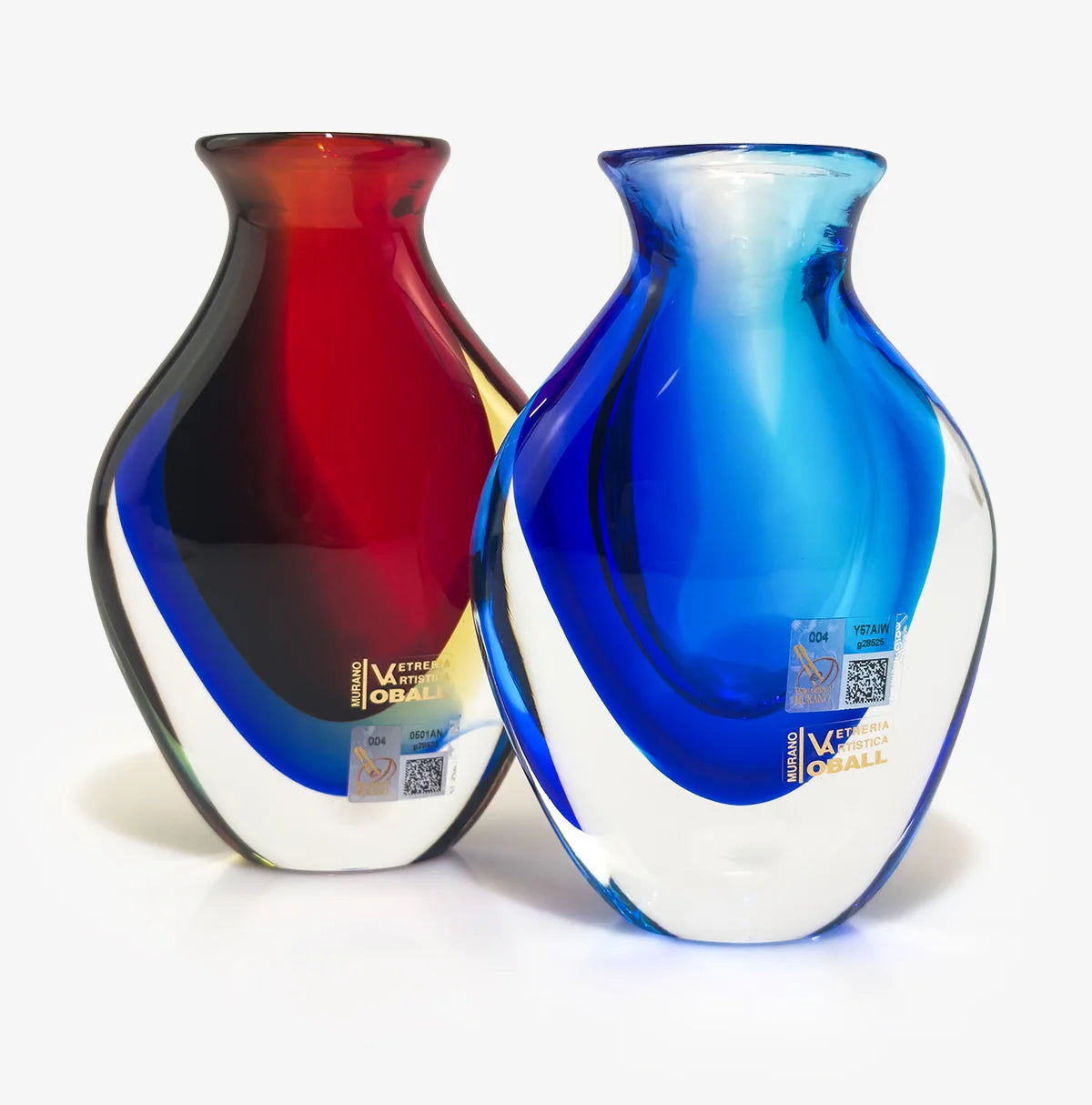 Two decorative glass vases with a rounded, hourglass-like silhouette, one featuring a red-to-black gradient with a blue base, and the other featuring a blue-to-white gradient with a dark blue base. Both vases have protective stickers on the lower portion and are set against a plain white background.