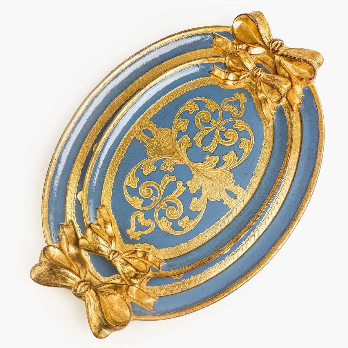 Two carved oval, dusty blue and gold Florentine trays with a bow detail. A medium sized tray is set inside a large tray.