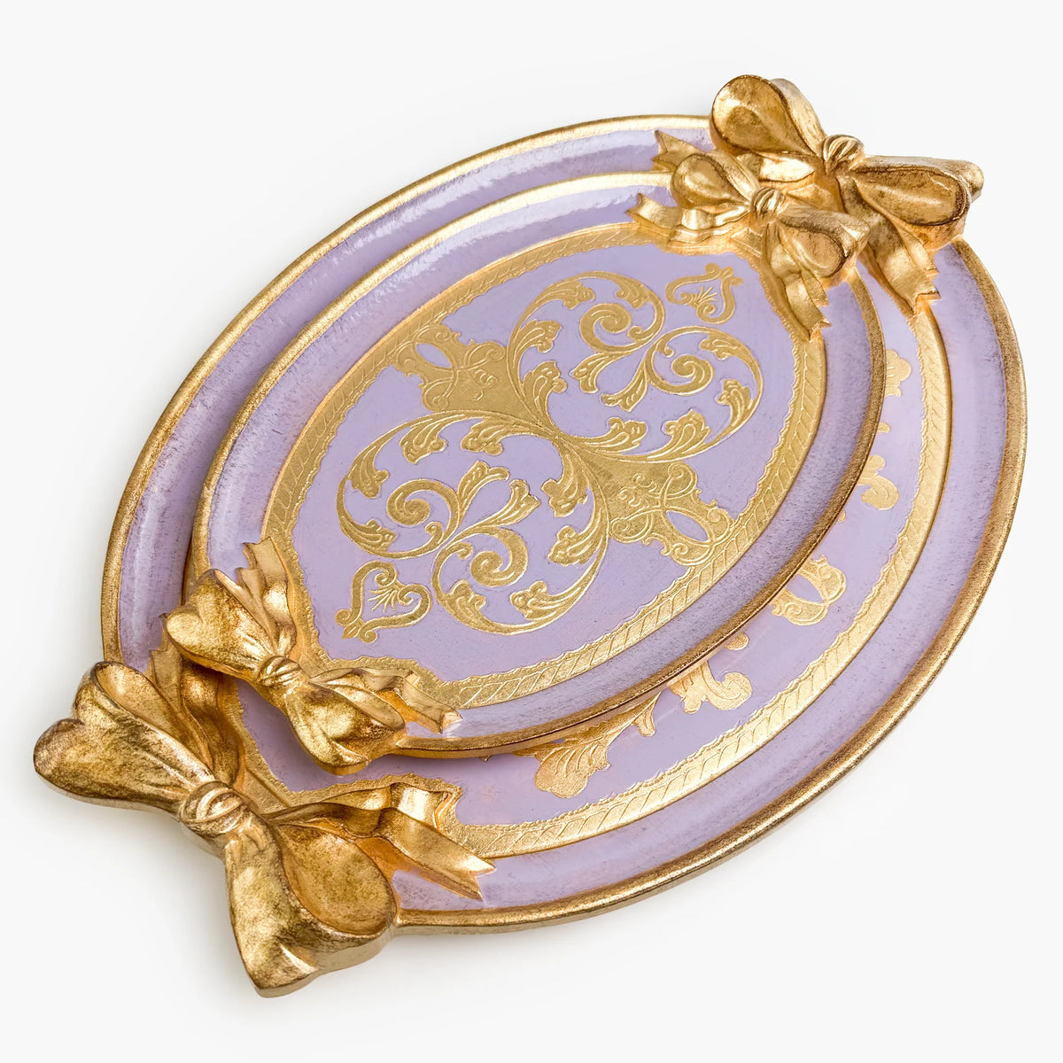 Two carved oval, lilac and gold Florentine bow trays with a bow detail, side by side.