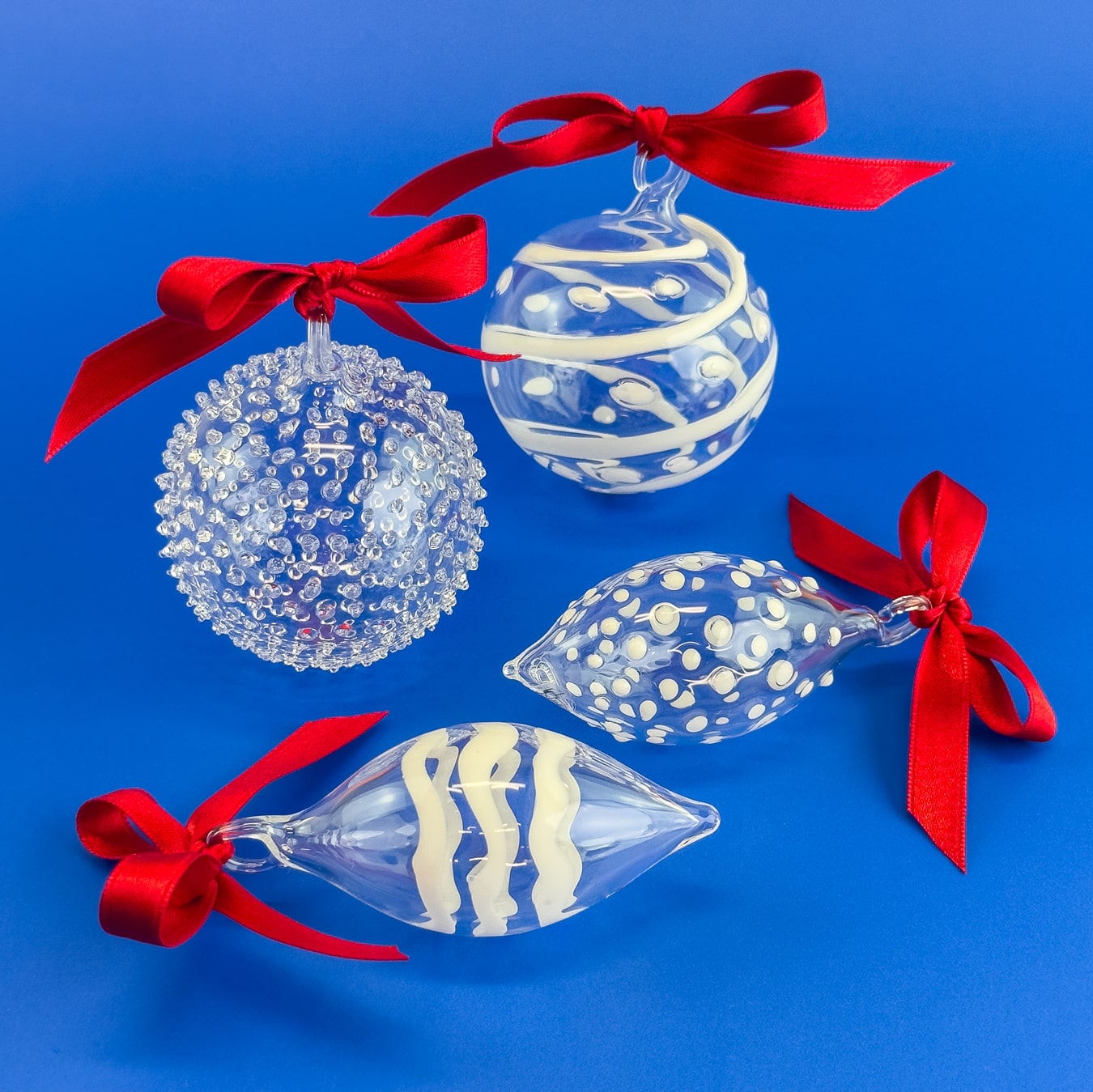 Set of four blown clear glass holiday ornaments with textured surface, made in Italy, by My Italian Decor.