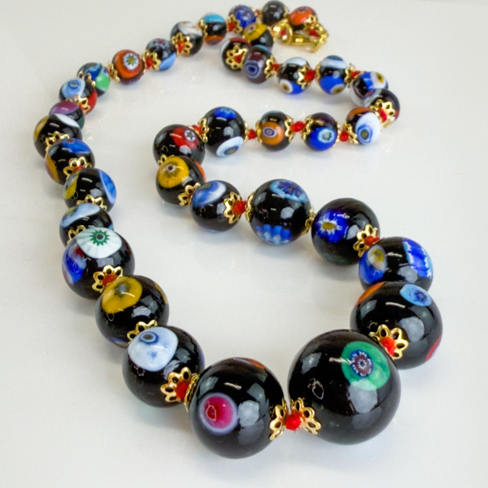 Black beaded Millefiori necklace made with Murano glass, featuring colorful floral patterns on a sleek design.