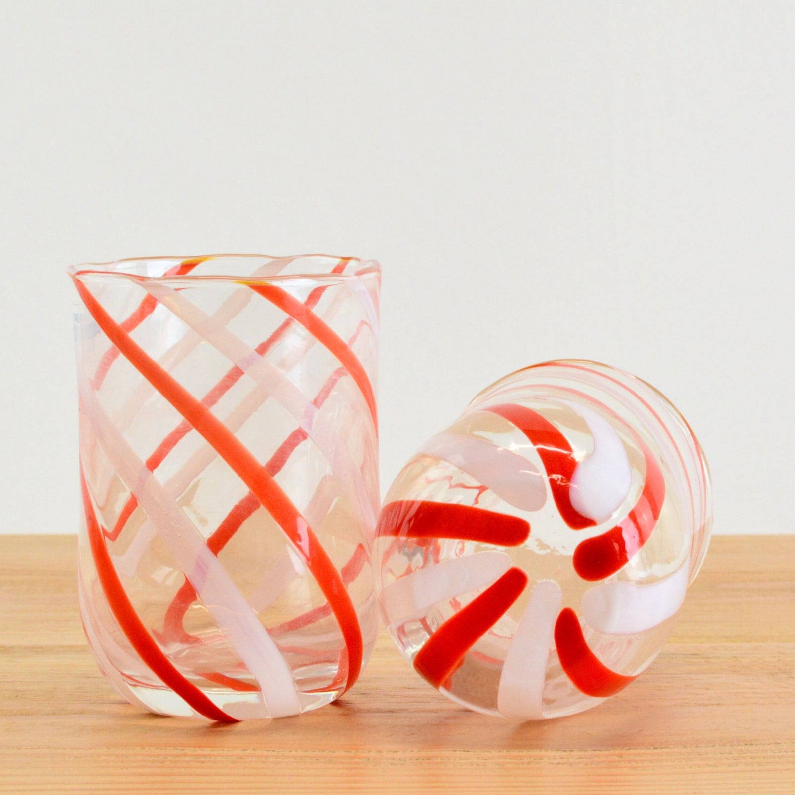 Set of 2 red spiral glass tumblers by MZ, featuring a vibrant red striped design and clear glass construction.