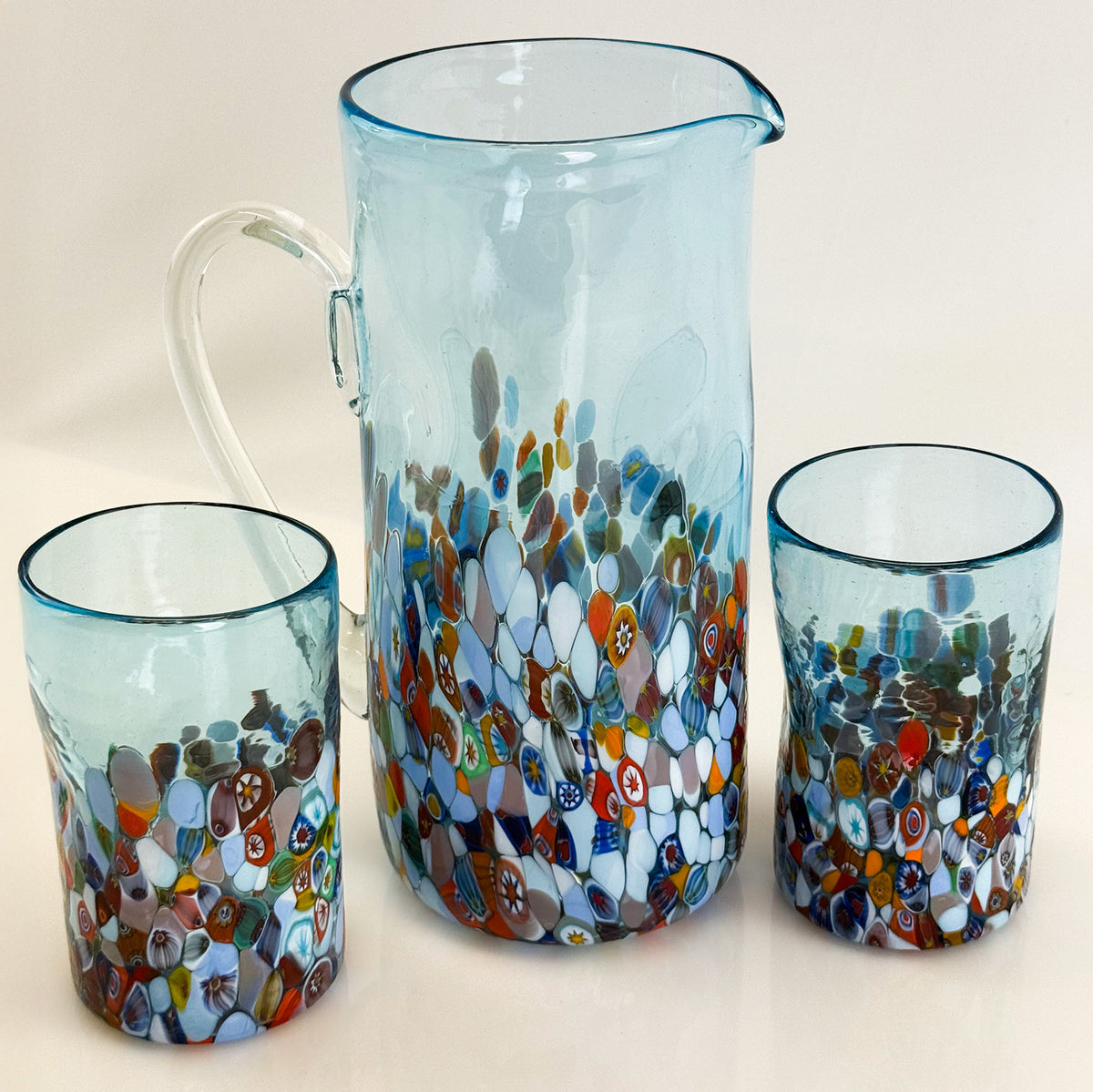Set of glass pitcher and tumblers with mosaic pattern on a light background
