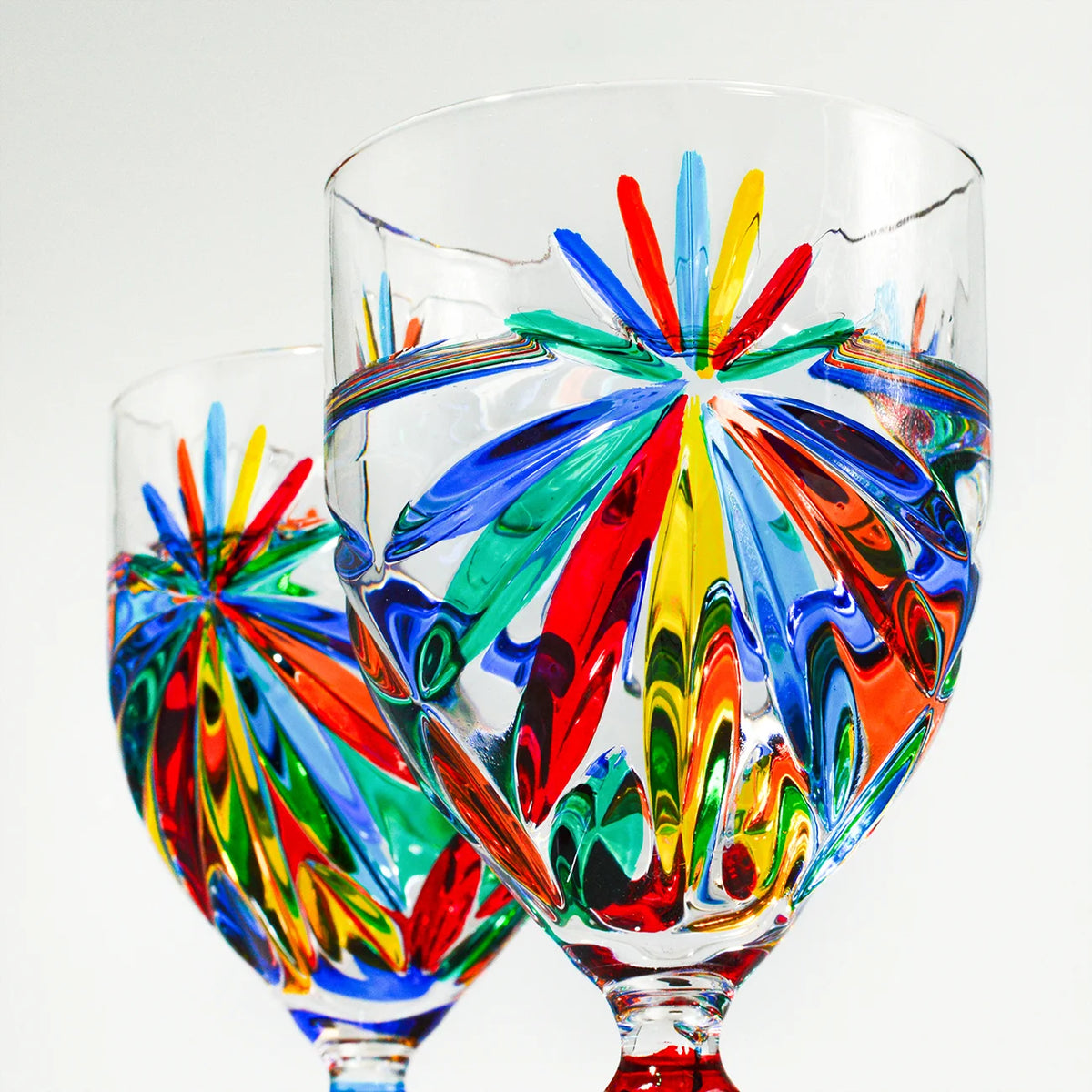 Two hand-painted Italian crystal starburst wine glasses by DZ, elegant goblets with intricate designs for enjoying wine.