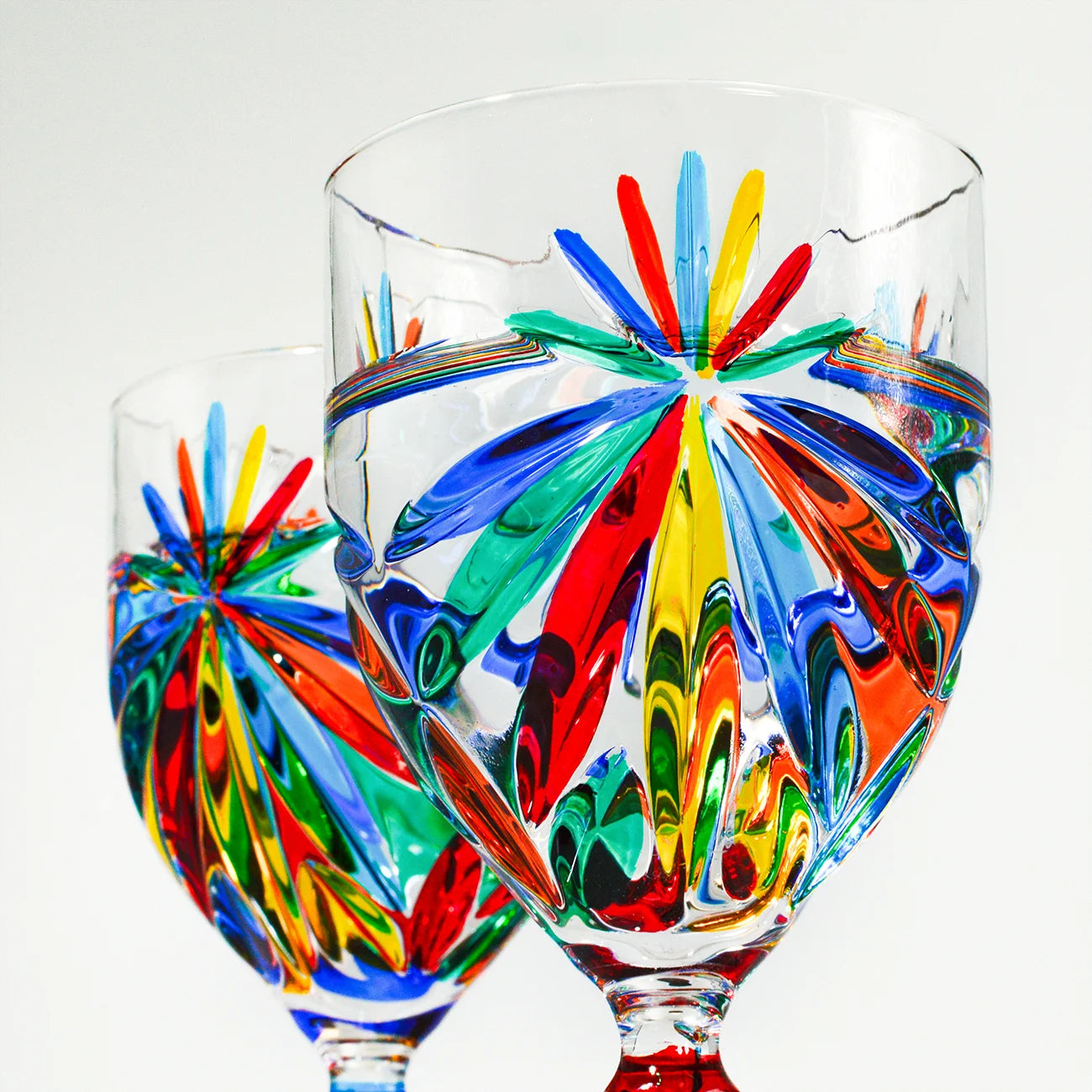 Two hand-painted Italian crystal starburst wine glasses by DZ, elegant goblets with intricate designs for enjoying wine.
