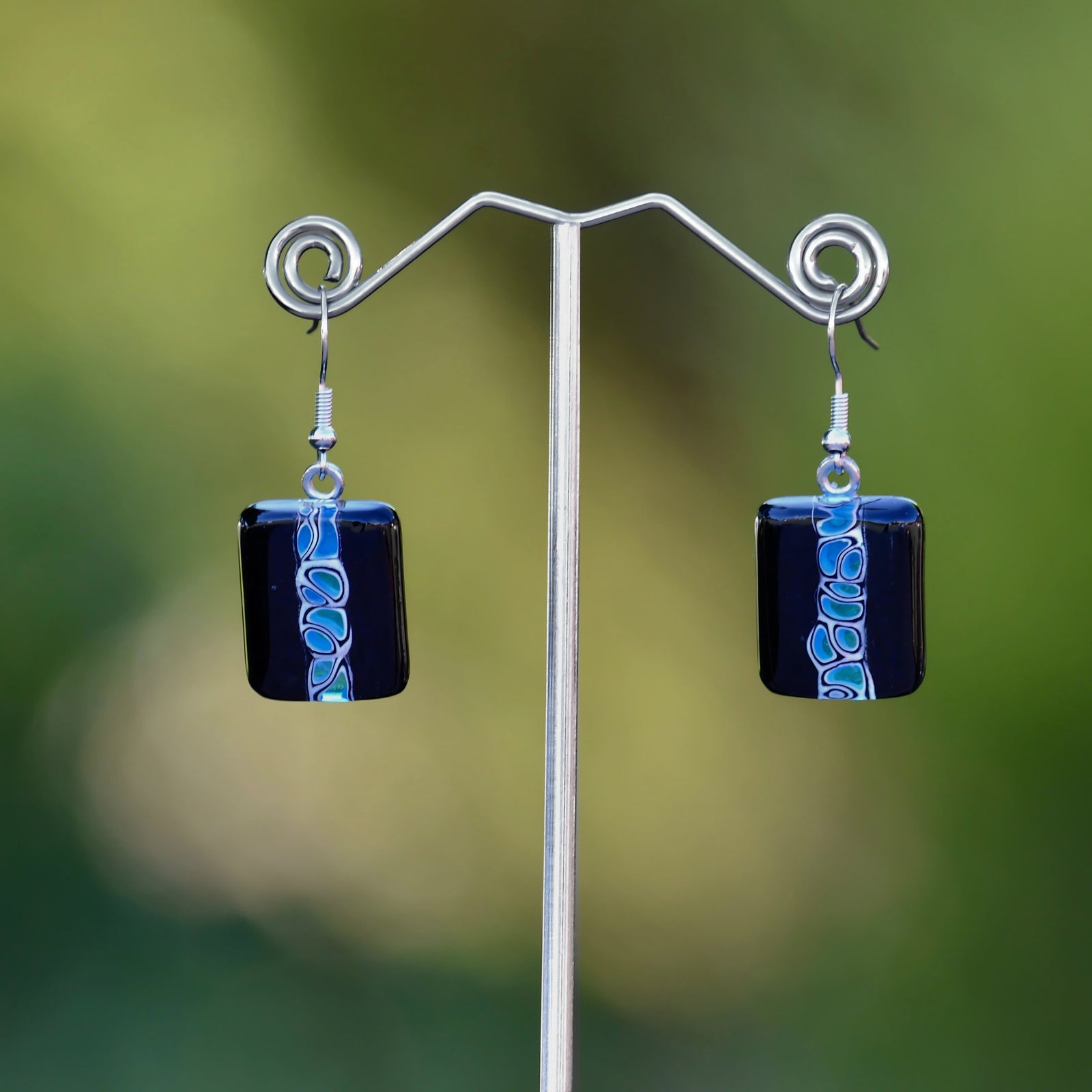 Close-up of Giro Black and Blue Murano Glass Murrine earrings featuring intricate blue and black glass bead designs.