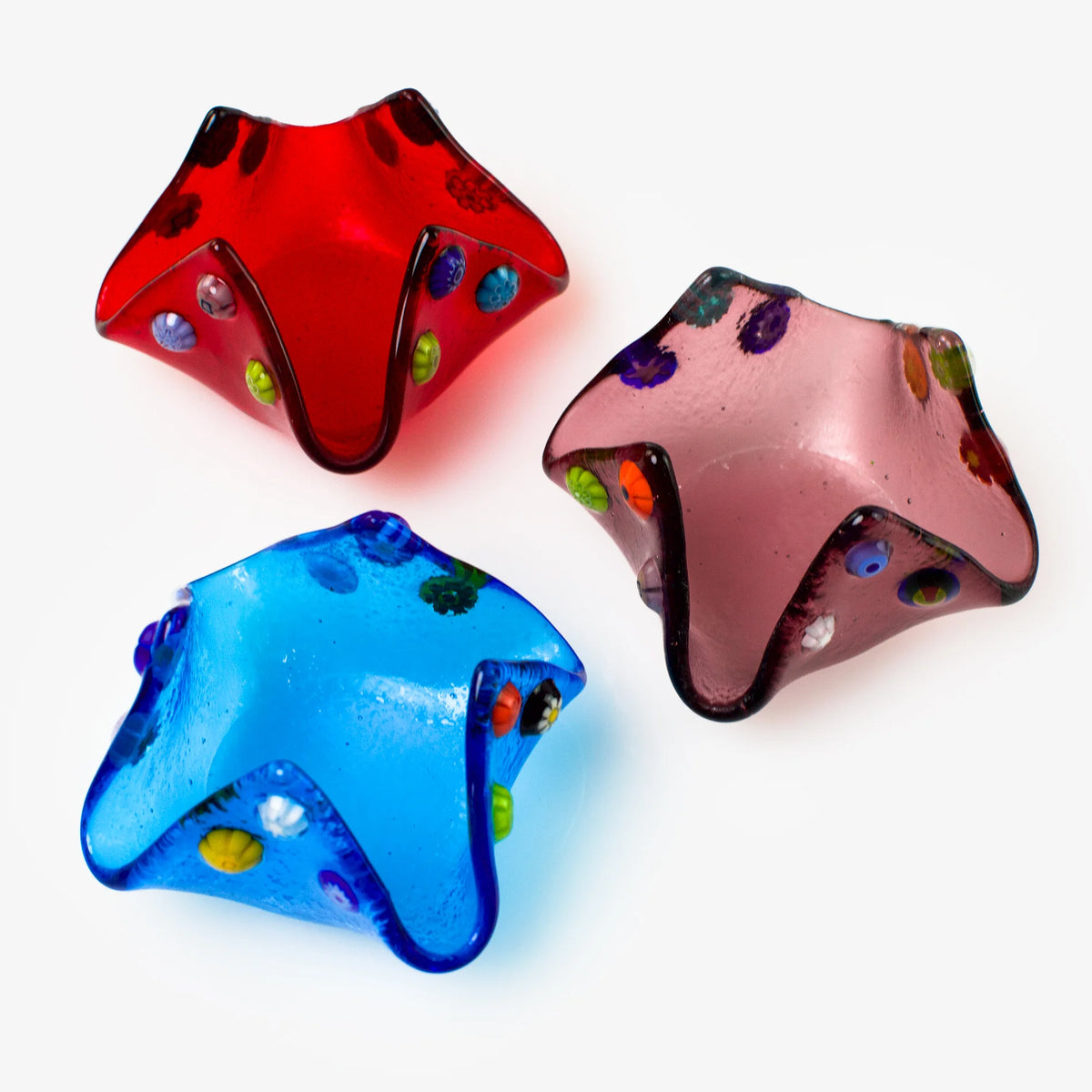 Colorful Murano glass Millefiori candle votive holder on a decorative Italian tray, showcasing intricate glasswork and vibrant patterns.