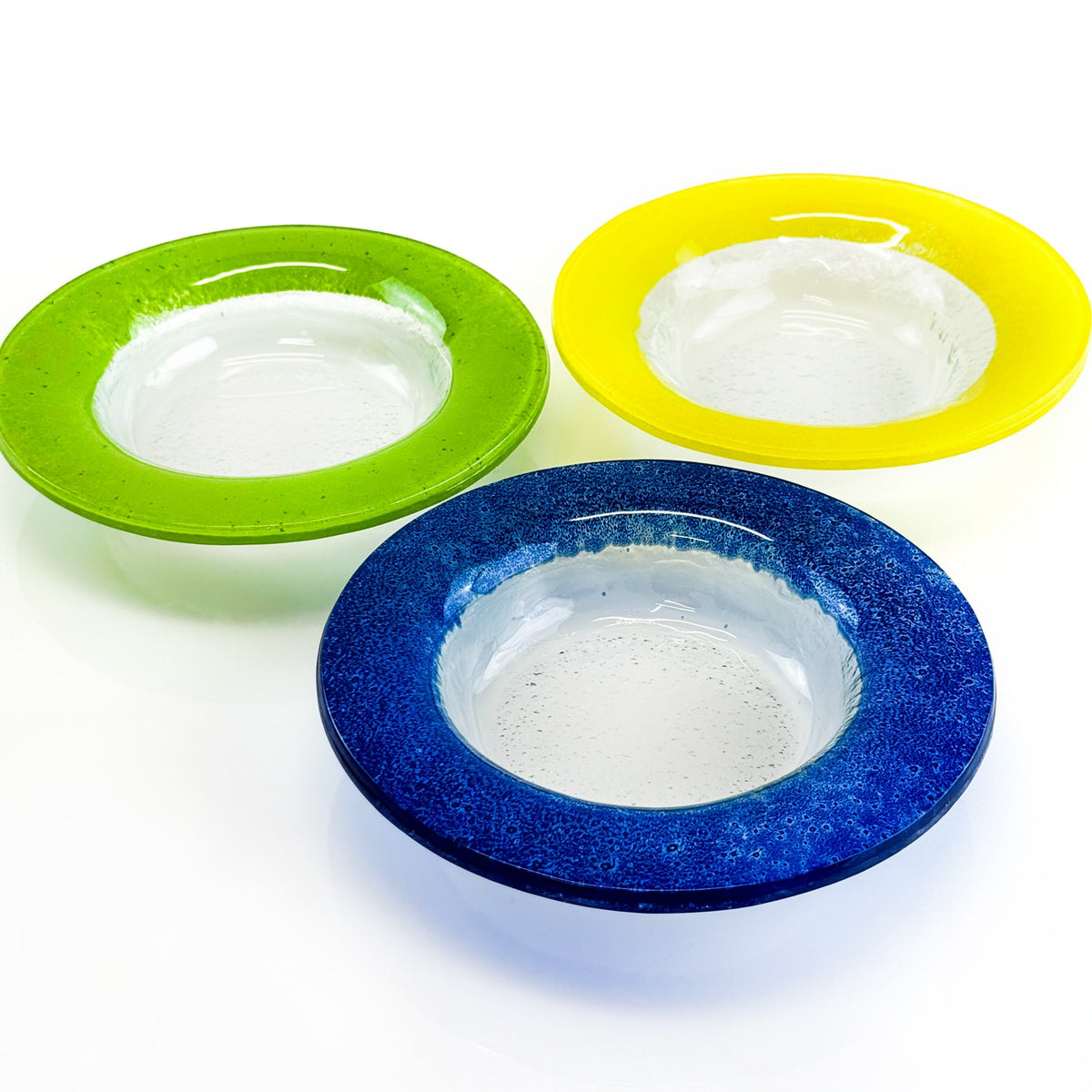 Three colorful bowls in green, yellow, and blue on a white background