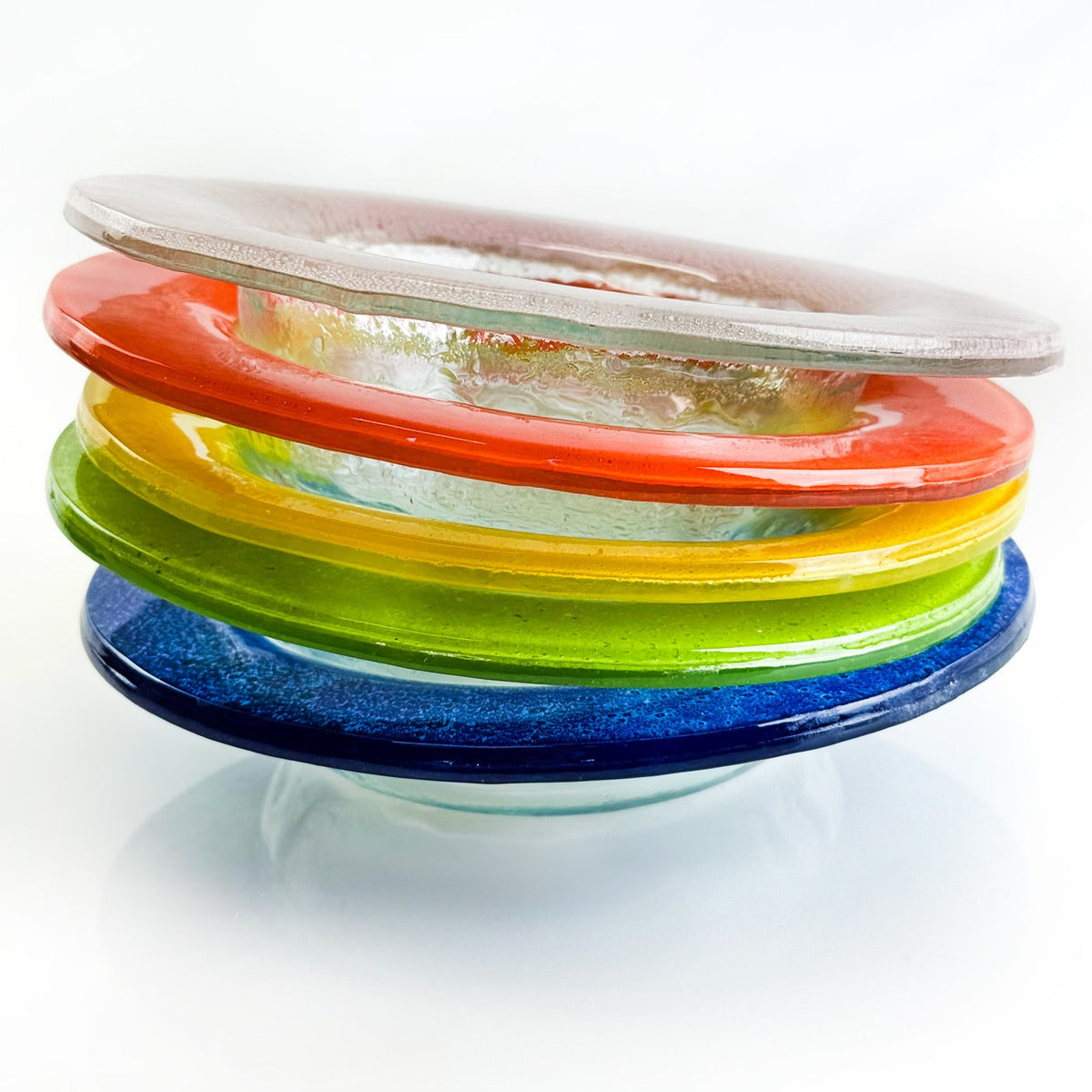 Stack of colorful glass plates on a white background