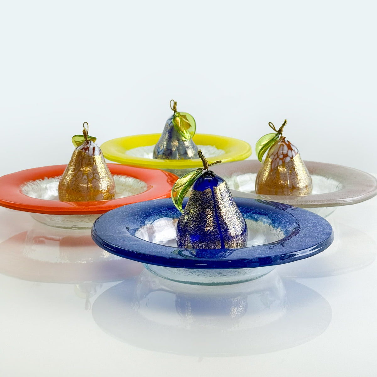 Decorative glass bowls with fruit-shaped ornaments on a white background
