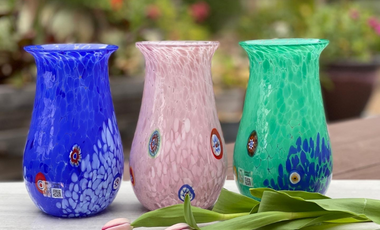 Three Murano Glass vases on a table. From left to right : blue, pink and green