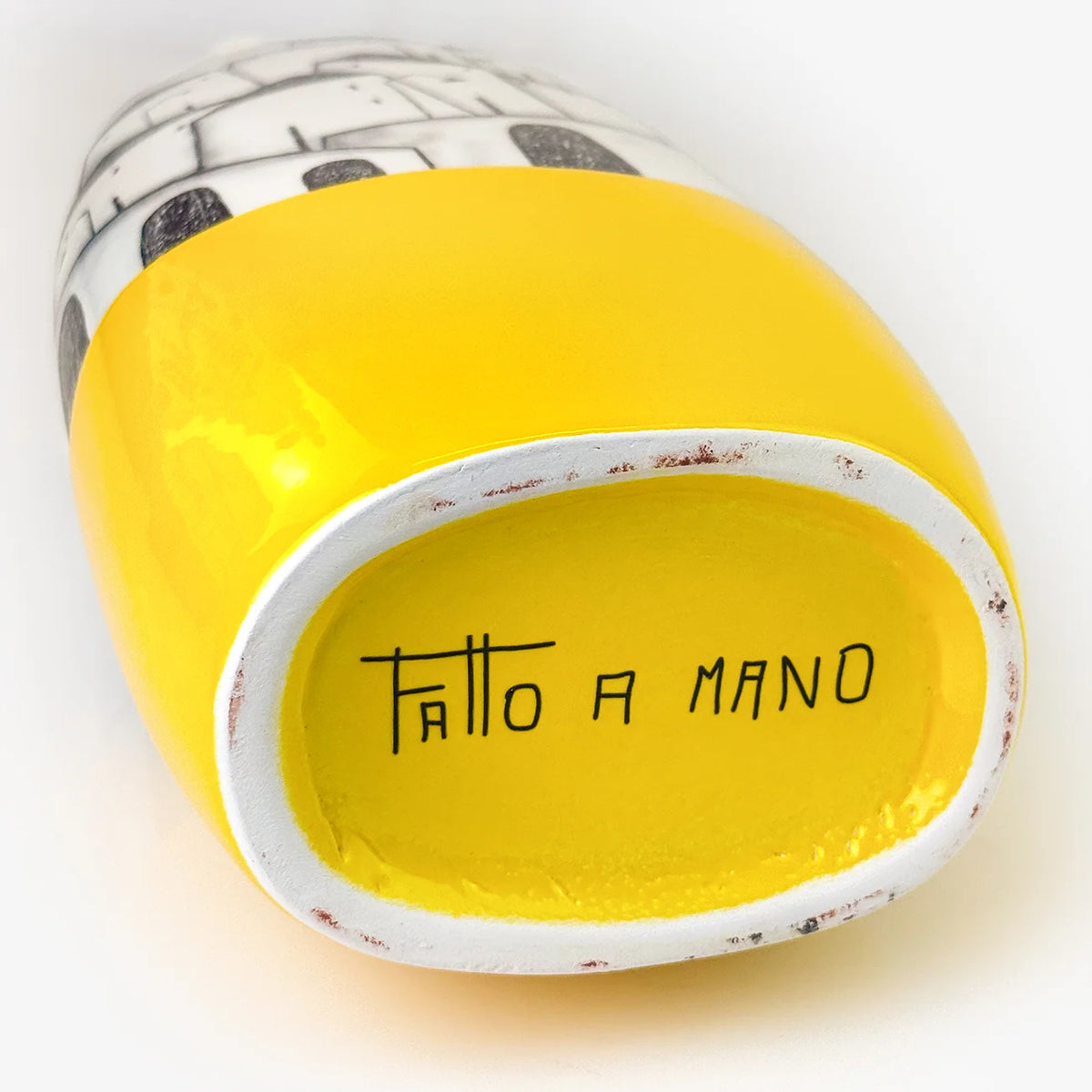 Close-up of the bottom opening of a glossy ceramic vase.