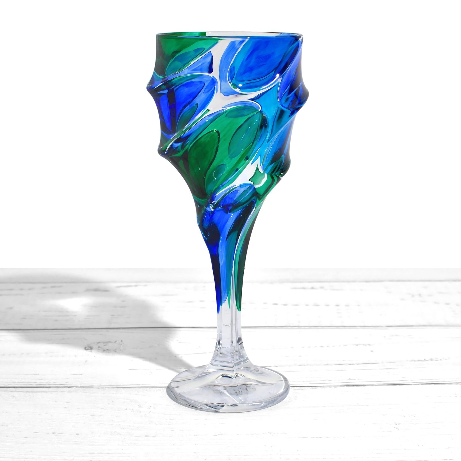 Set of two DZ Caly Italian crystal wine glasses in blue and green with elegant, curved design.