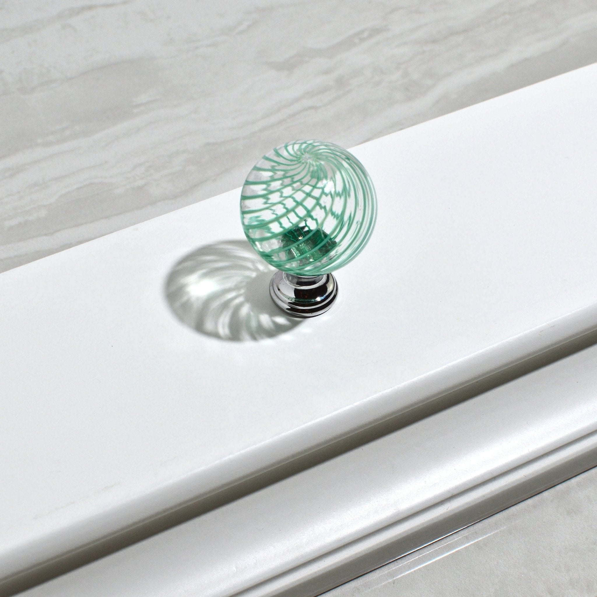 Green Murano glass Filigrana cabinet drawer knob pull on wood surface, handcrafted Italian home décor accessory by My Italian Decor.