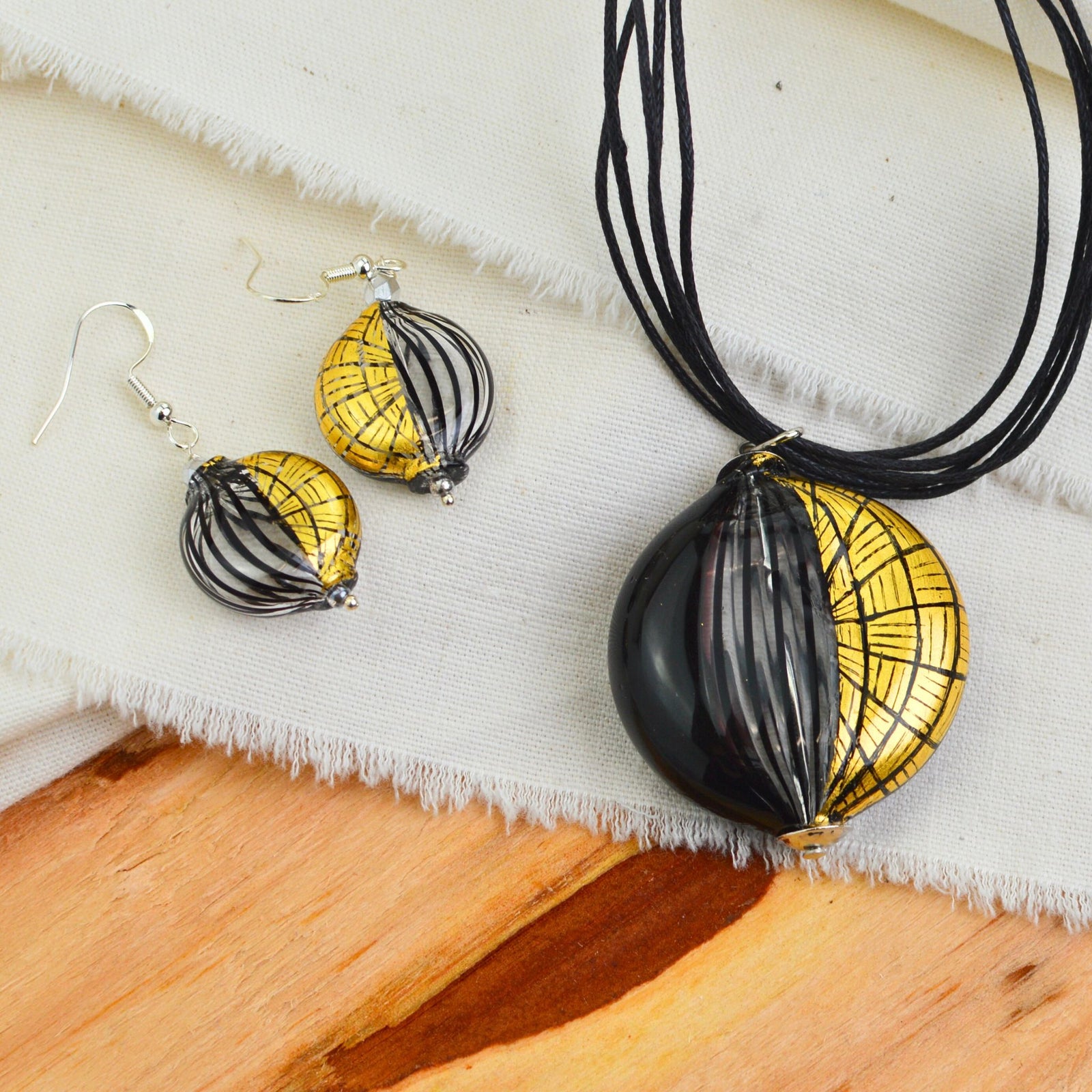 Handcrafted Murano Glass jewelry set with black and gold necklace and earrings, featuring etched glass designs, made in Italy.