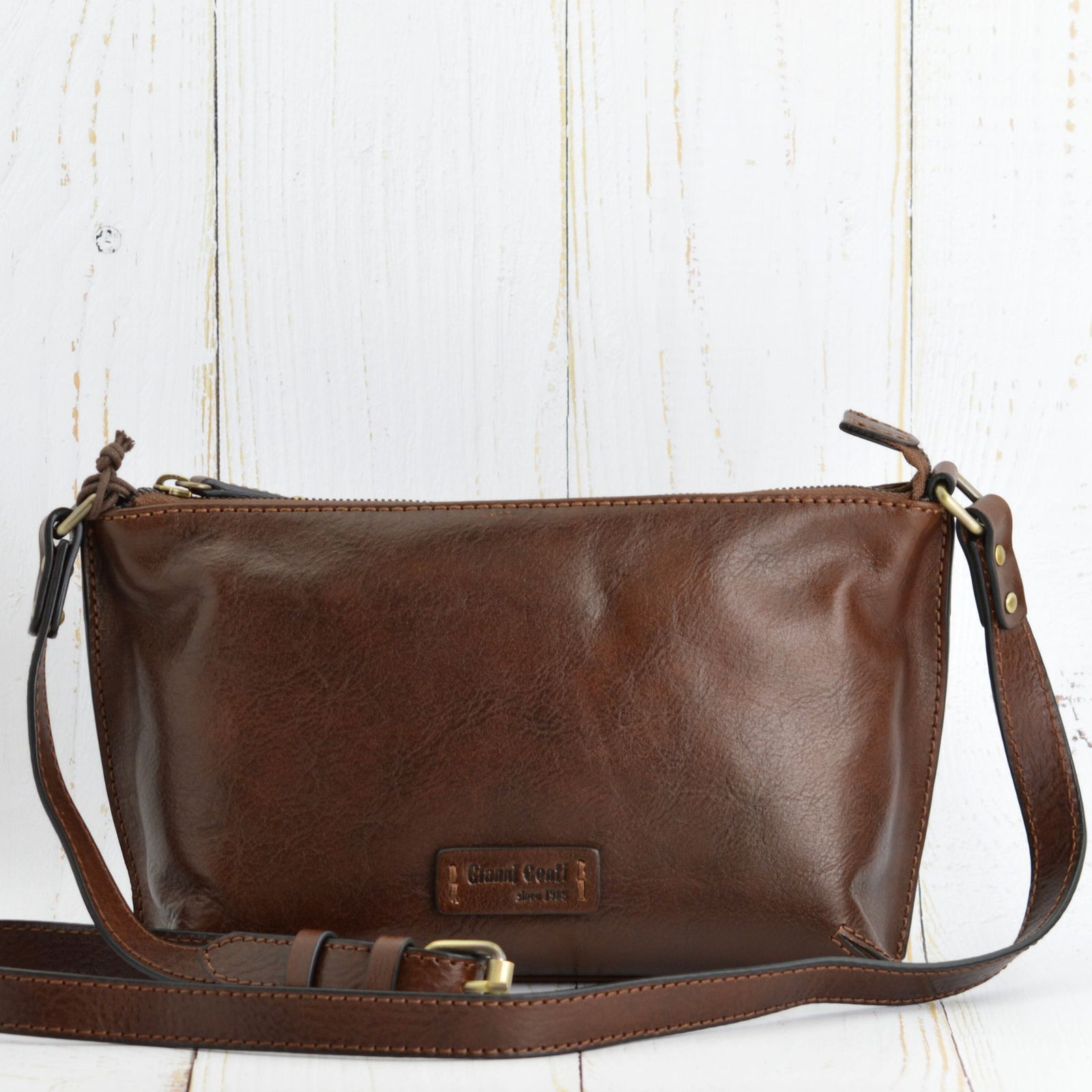 Brown Firenze Italian leather crossbody handbag with adjustable strap, made in Florence, Italy, showcasing a side view.
