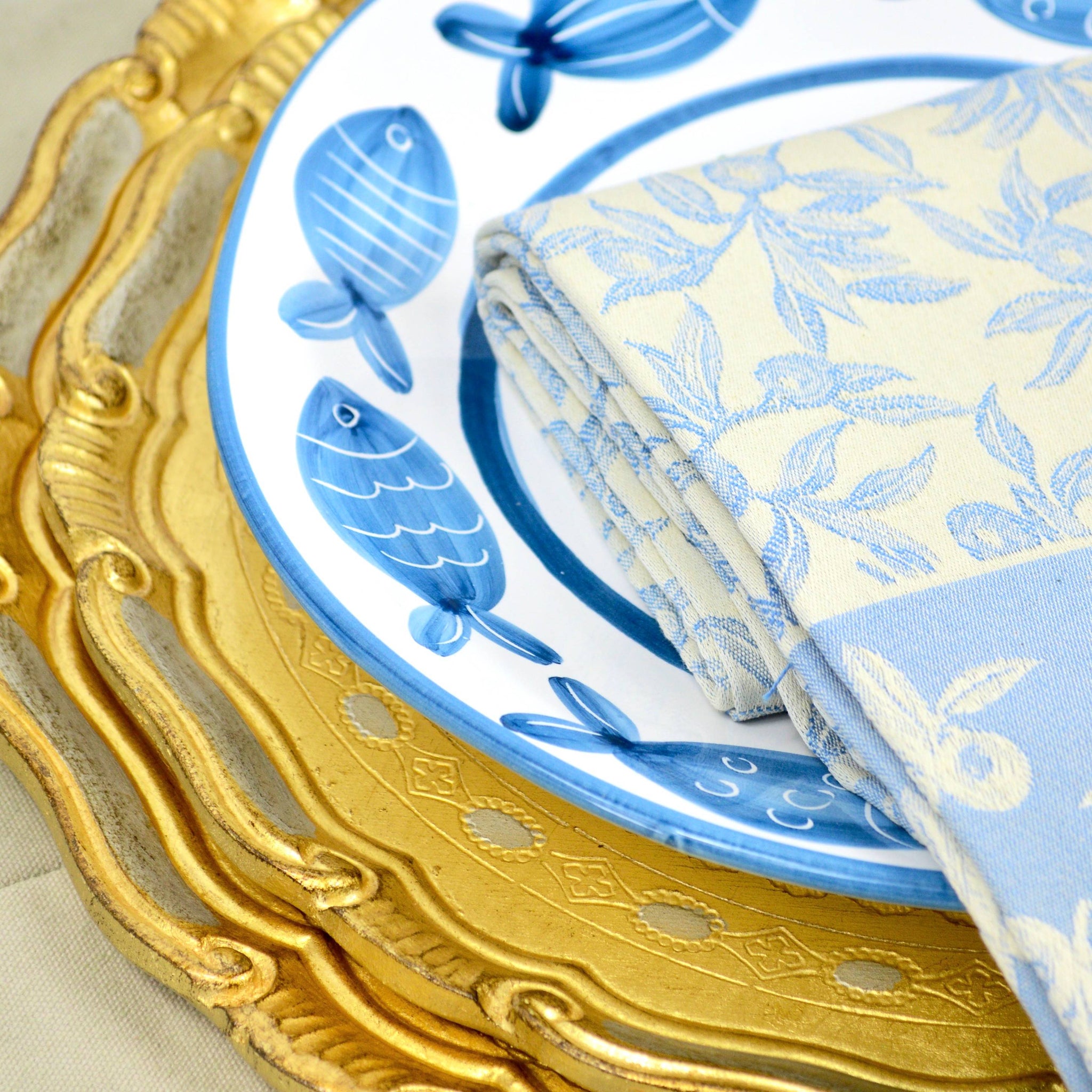 Colorful Busatti Oliva kitchen towel with Italian craftsmanship, featuring a fish and gold tray design.