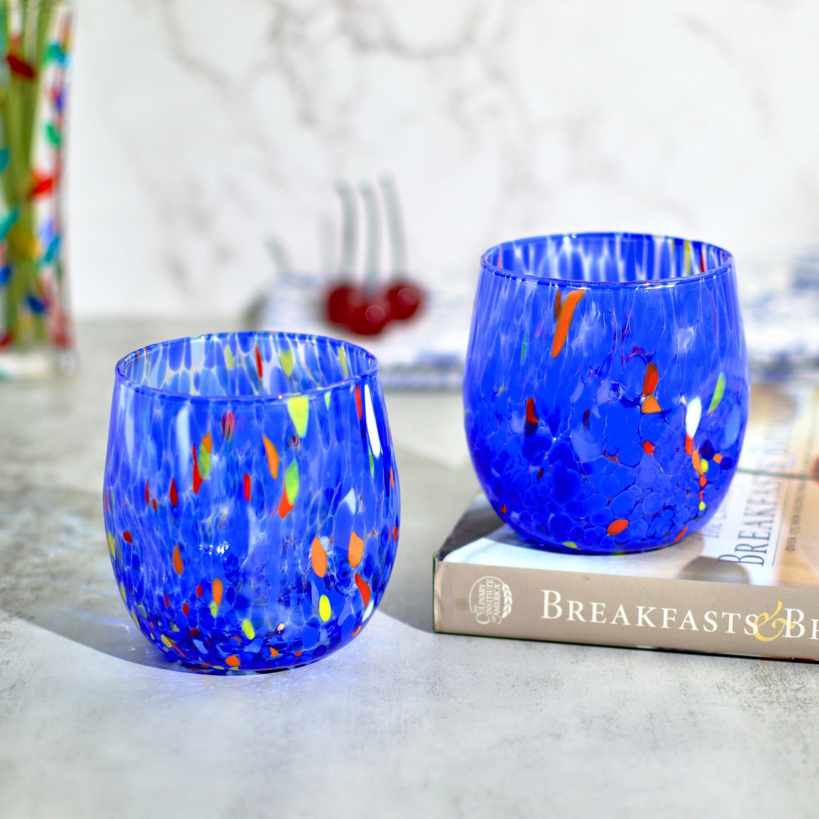 Set of two Murano glass round tumblers in vibrant colors from Italy, featuring elegant craftsmanship and clear design.