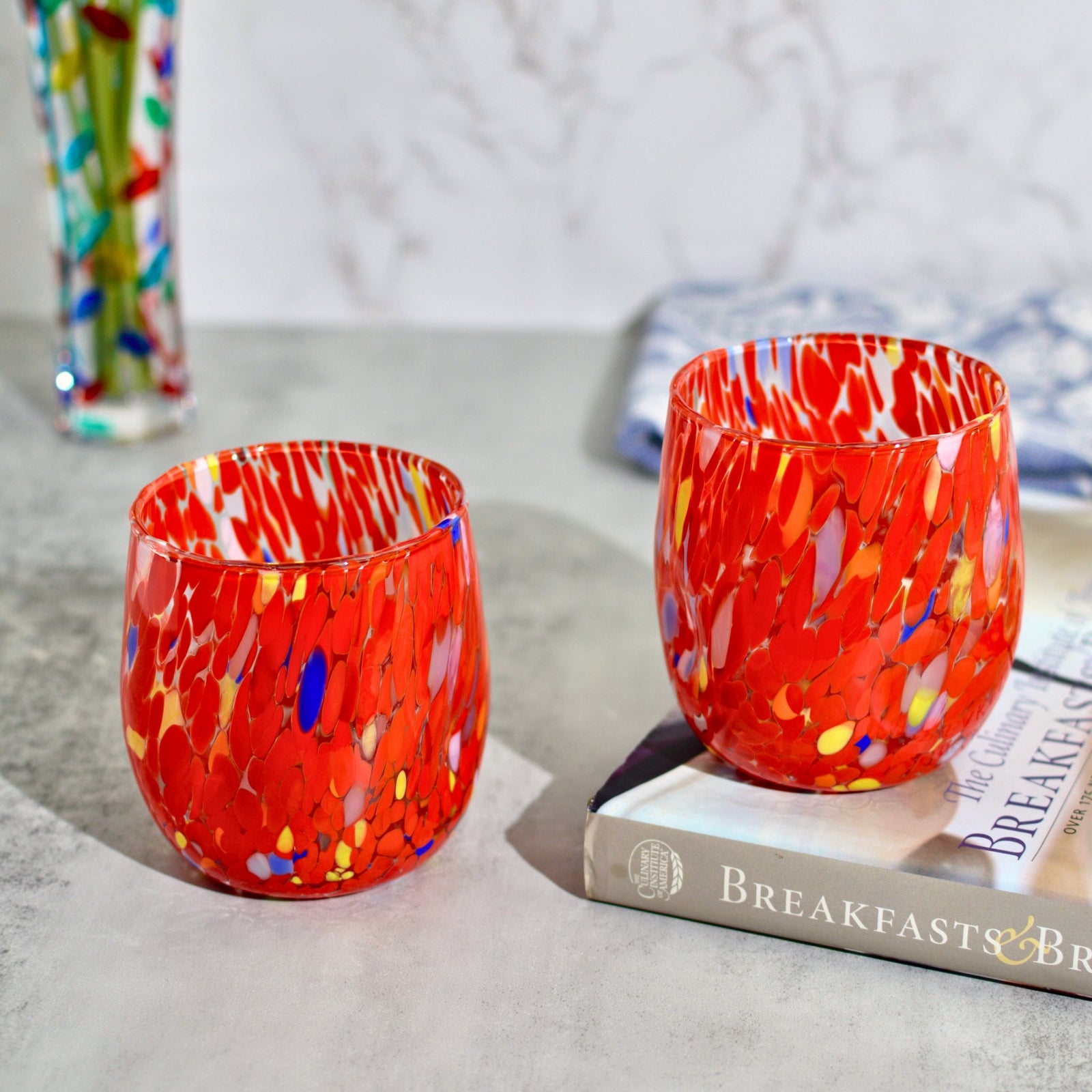 Set of two Murano glass round tumblers in vibrant colors from Italy, featuring elegant craftsmanship and clear design.