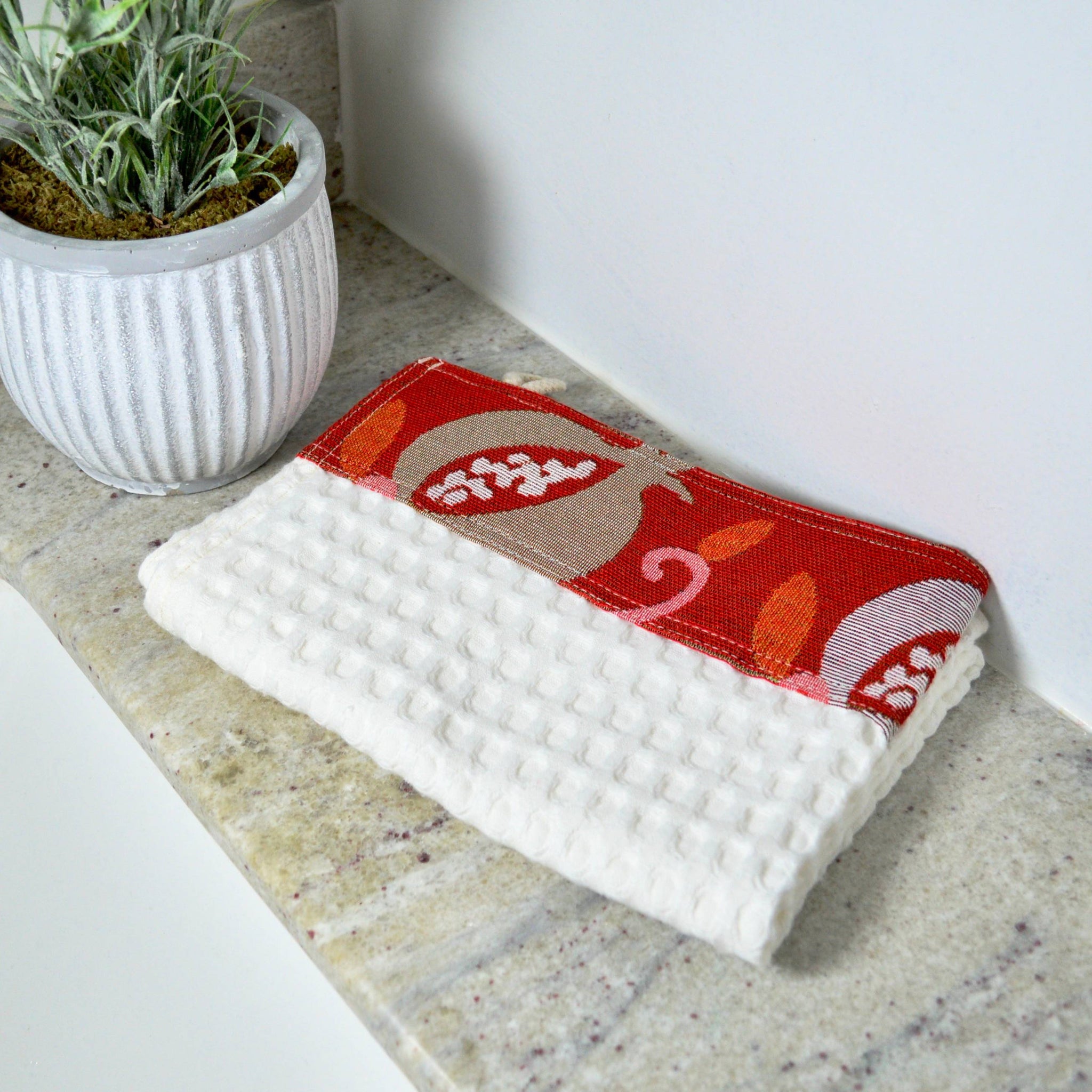 Assorted colorful kitchen towels from My Italian Decor, made in Italy, displayed next to a sink for stylish kitchen decor.