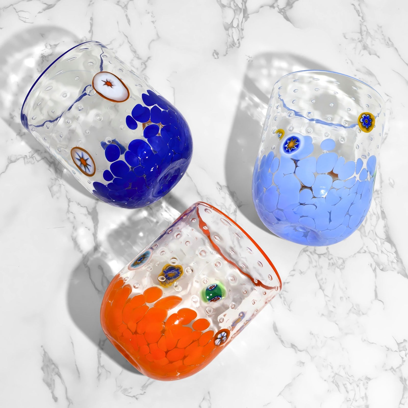 Colorful Millefiori Murano tumblers by Gioia Color, made in Italy, with vibrant glass patterns and clear base.
