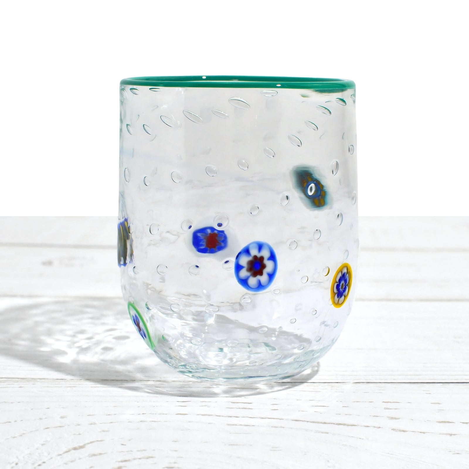 Set of four Gioia Clear Millefiori Murano tumblers with colorful rims, made in Italy, showcasing vibrant hand-blown glass design.